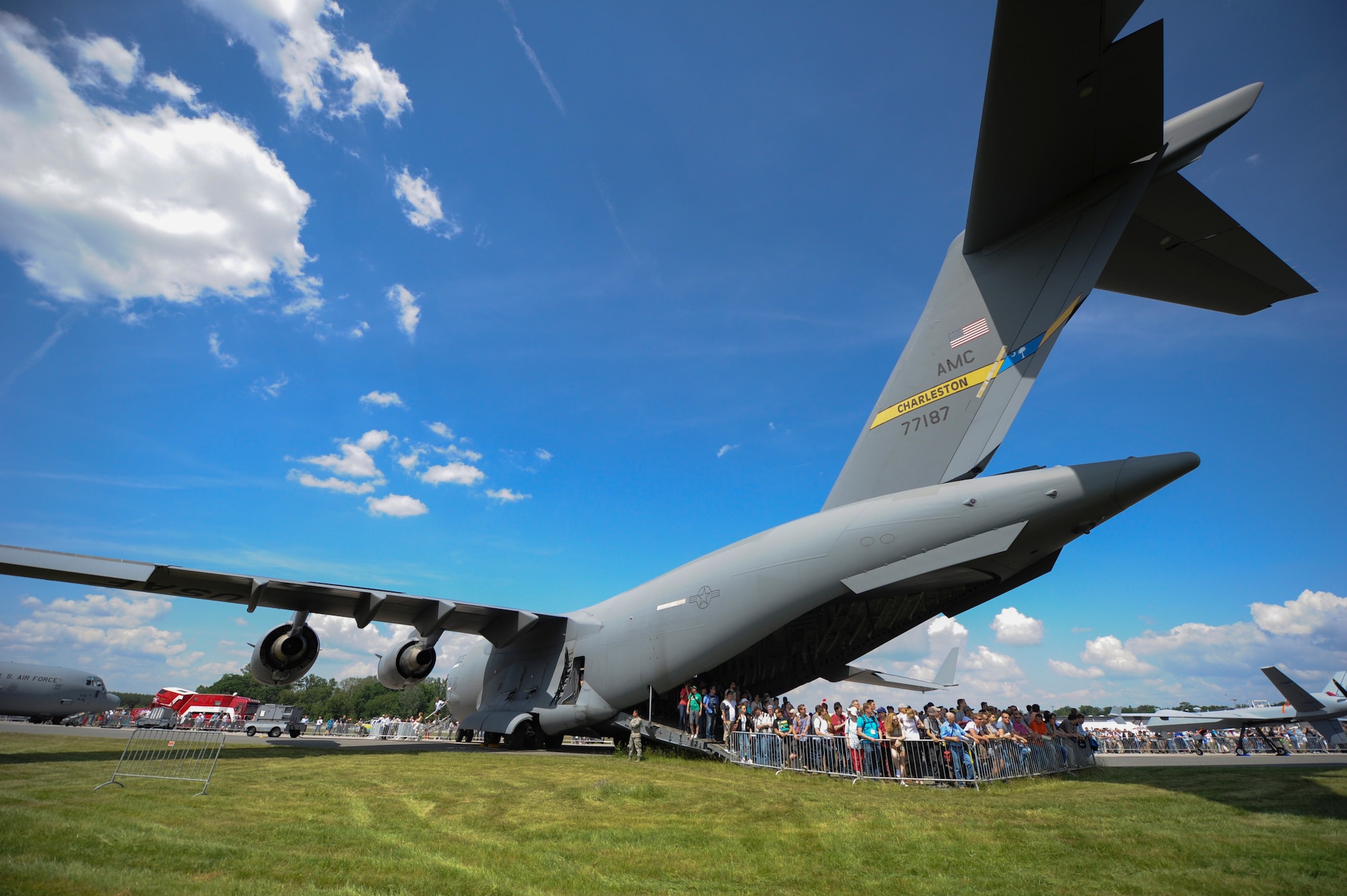 Spectators take advantage of the cool shade beneath The Spirit of Berlin, a Charleston C-17 Globemaster in the early hours of the 2016 Berlin Airshow June 2. The show had approximately 230,000 visitors and exhibitors from more than 65 countries. (U.S. Air Force photo by Senior Airman Tom Brading)