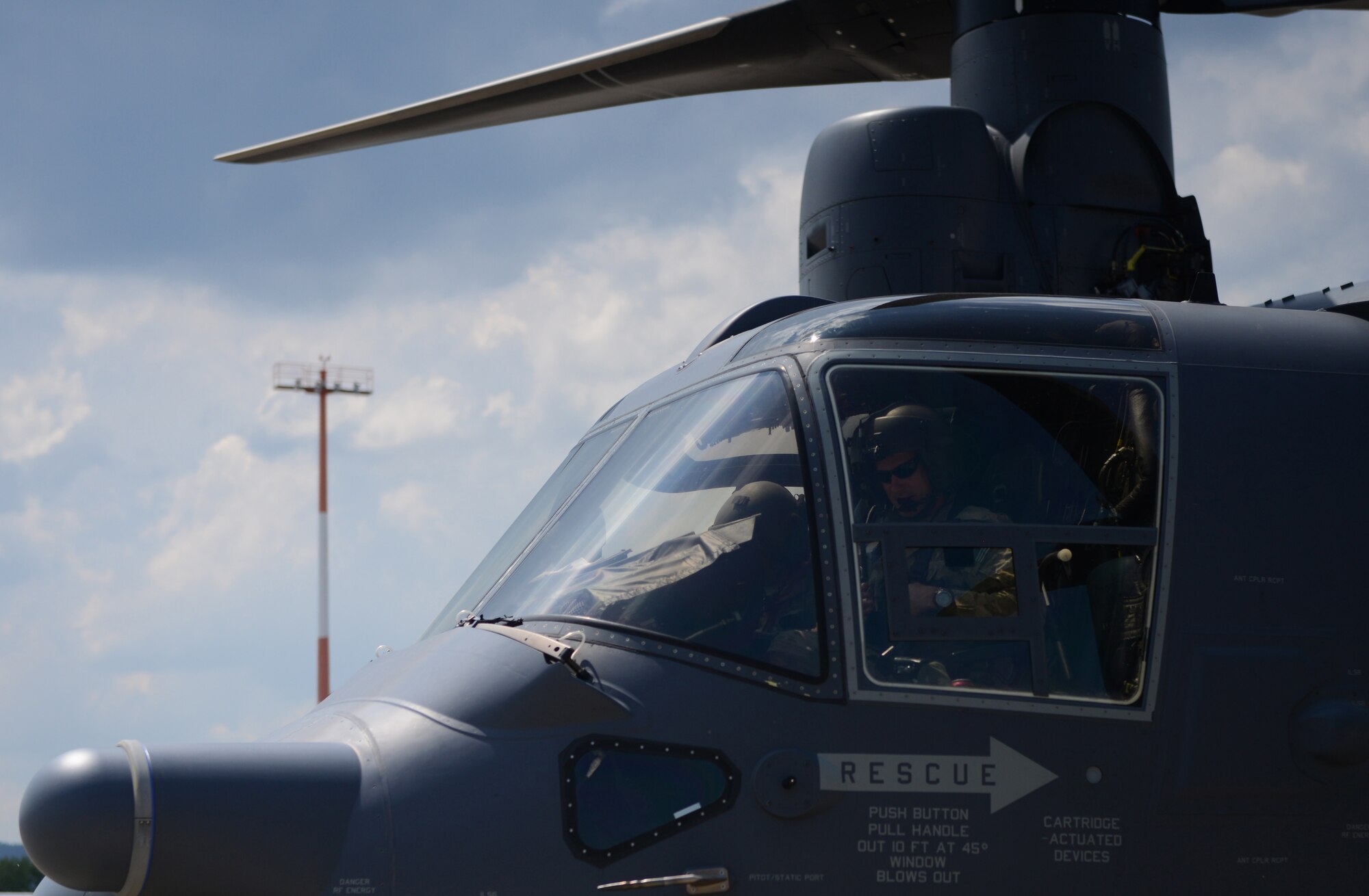 A flightline worker at Ramstein Air Base, Germany, pulls chocks as a CV-22 Osprey from the 7th Special Operations Squadron at Royal Air Force Mildenhall, England, taxis for take-off June 6, 2016. The CV-22 crew transitted through Ramstein after participating in the D-Day Remembrance airdrops in Normandy, France. (U.S. Air Force Photo/ Airman 1st Class Joshua Magbanua)

