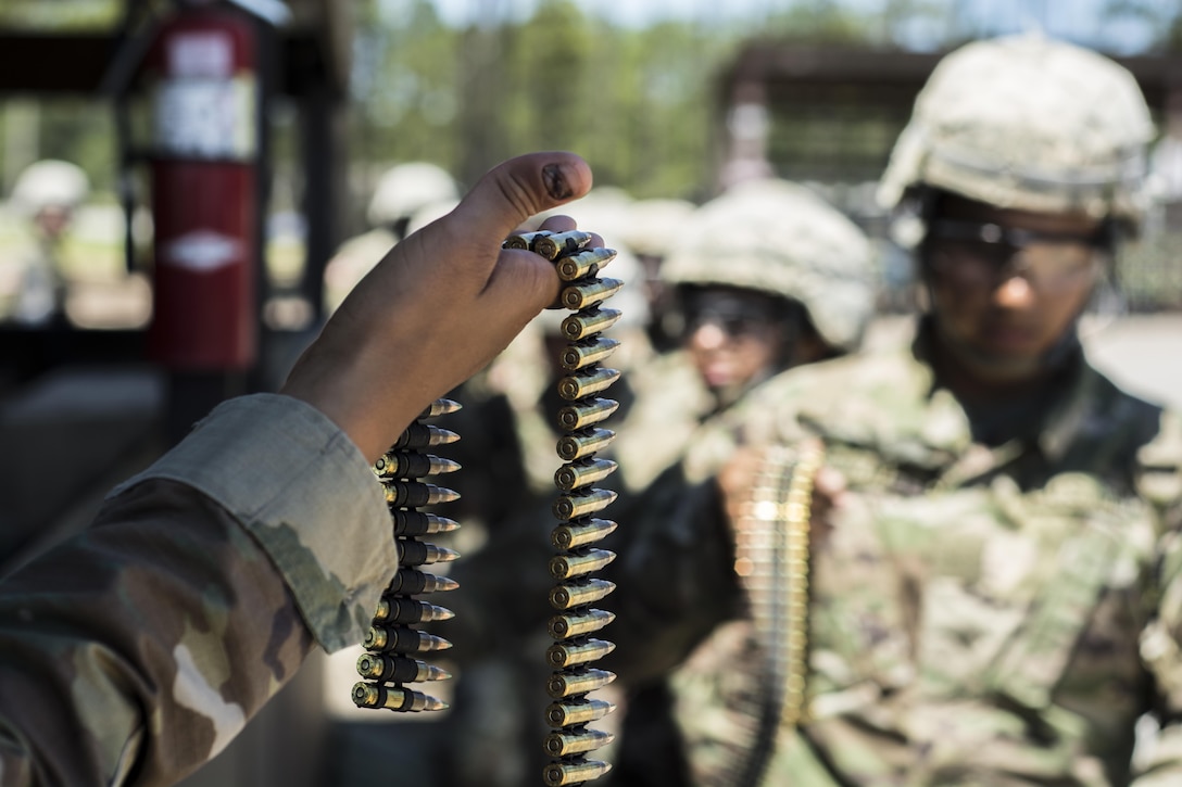 Soldiers in their 6th week of Basic Combat Training with Co. A, 3rd Bn., 39th Inf. Reg., recieve a belt of 5.56 mm rounds before firing the M249 Light Machine Gun at the U.S. Weapons Demonstration range at Fort Jackson, S.C., June 8. (U.S. Army photo by Sgt. 1st Class Brian Hamilton/ released)