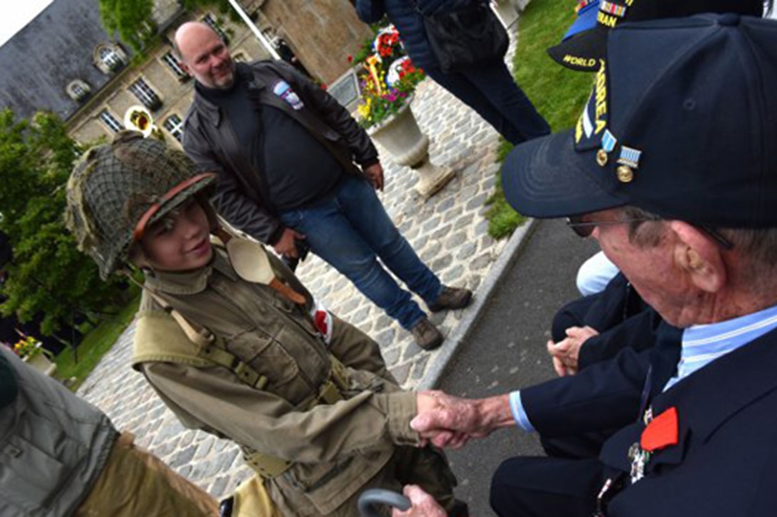 A French boy thanks veterans for freeing his country at the annual Cabbage Patch ceremony and parade commemorating the Battle of Carentan during the allied invasion of Normandy during World War II.