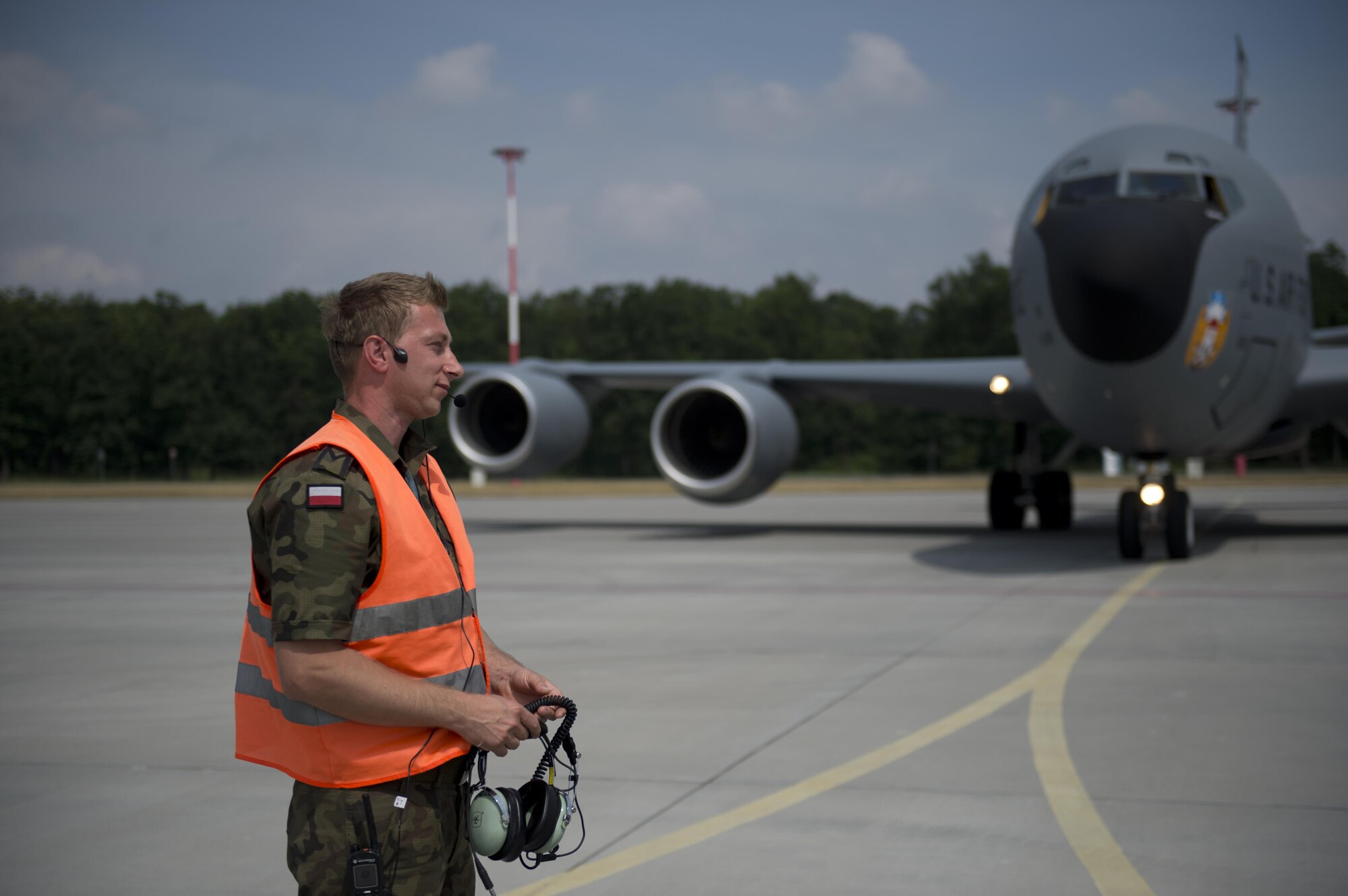 A Polish air force service member removes his headset after marshaling a KC-135 from the 100th Air Refueling Wing, England, in preparation for exercise Baltic Operations 2016 at Powidz Air Base, Poland, June 2, 2016. Fifteen NATO and two partner nations will participate in the 44th iteration of the multinational maritime exercise BALTOPS 2016 in Estonia, Finland, Germany, Poland, Sweden, and throughout the Baltic Sea, June 3-19, 2016. (U.S. Air Force photo by Senior Airman Erin Babis/Released)