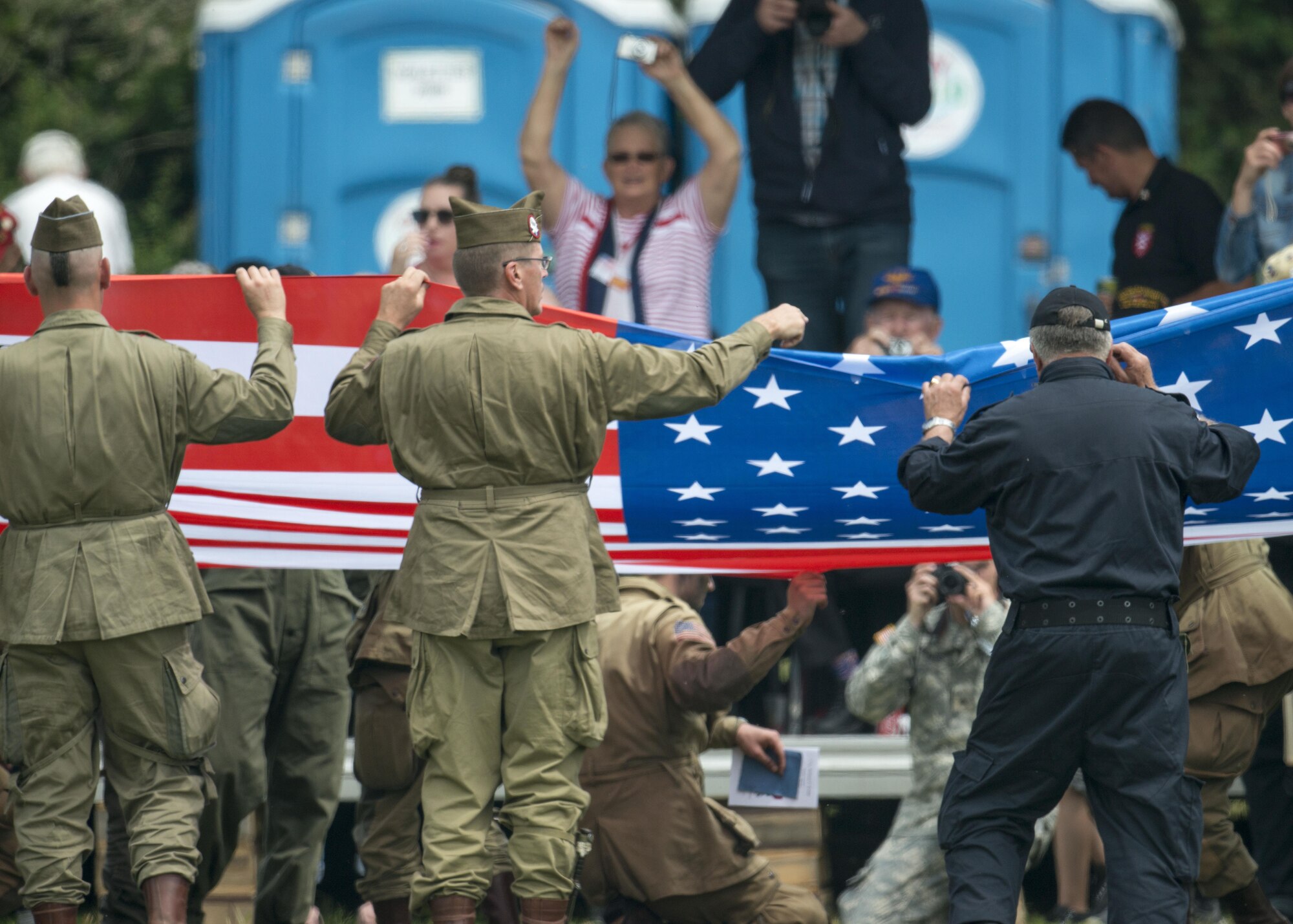 French civilians and retired military fold American flag during a Normandy Remembrance ceremony, June 5, 2016, in Sainte-Mère-Église, France. During the event, over 350 civilians and U.S. and French military from various services performed static and free fall jumps, formation marches and low-level flights. The event was in honor of the many airborne troops who lost their lives during the airdrop on D-Day, June 6, 1944. (U.S. Air Force photo by 1st Lt Chris Sullivan/Released)