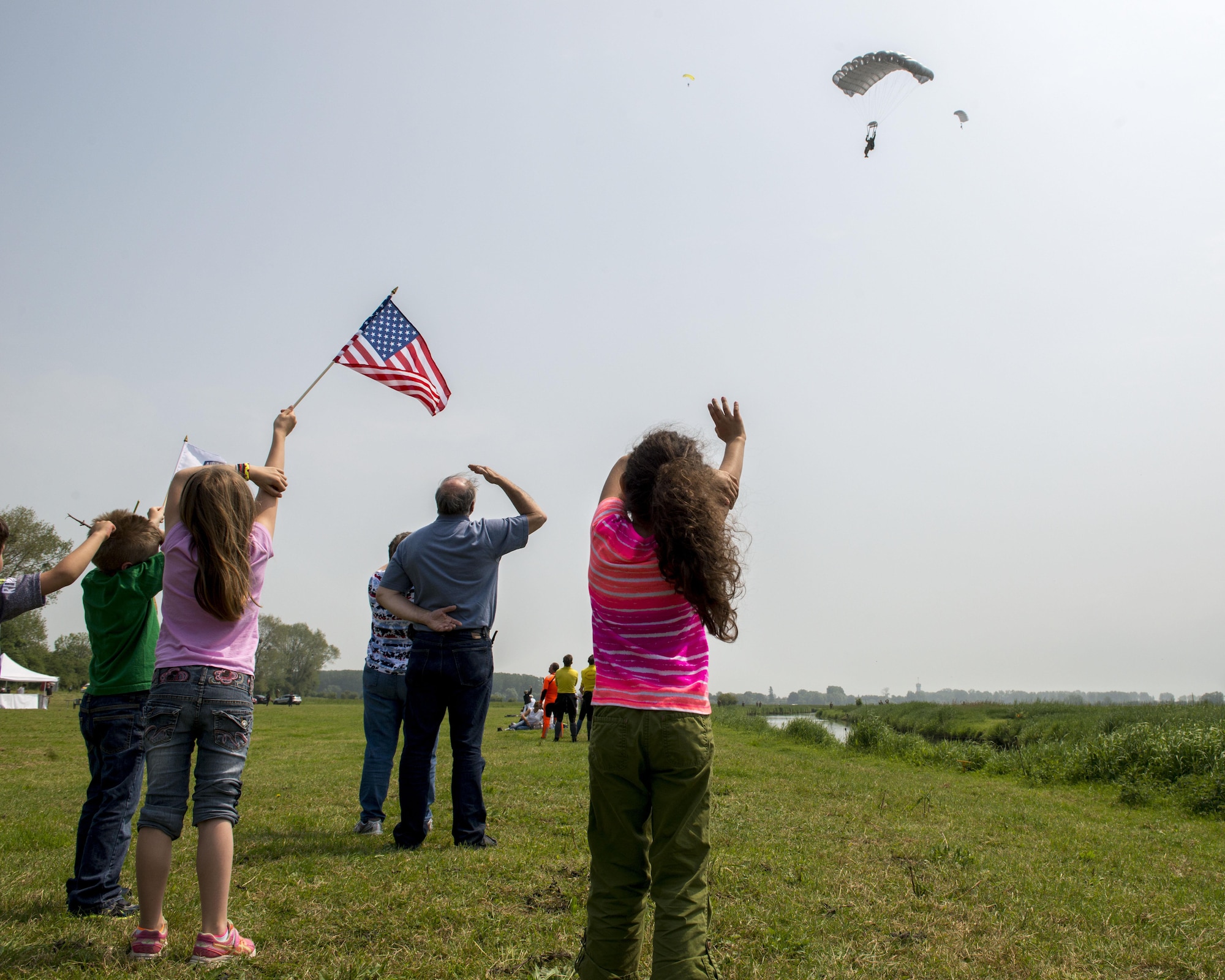 A U.S. Army Special Forces airborne soldier parachutes toward his family after jumping from a CV-22 Osprey, assigned to the 352d Special Operations Wing, June 5, 2016, over Sainte-Mère-Église, France. The jump was part of remembrance ceremony involving both MC-130J Commando II and CV-22 aircraft as well as Airmen from the 321st Special Tactics Squadron in honor of the many airborne troops who lost their lives during the airdrop on D-Day, June 6, 1944. (U.S. Air Force photo by 1st Lt Chris Sullivan/Released)