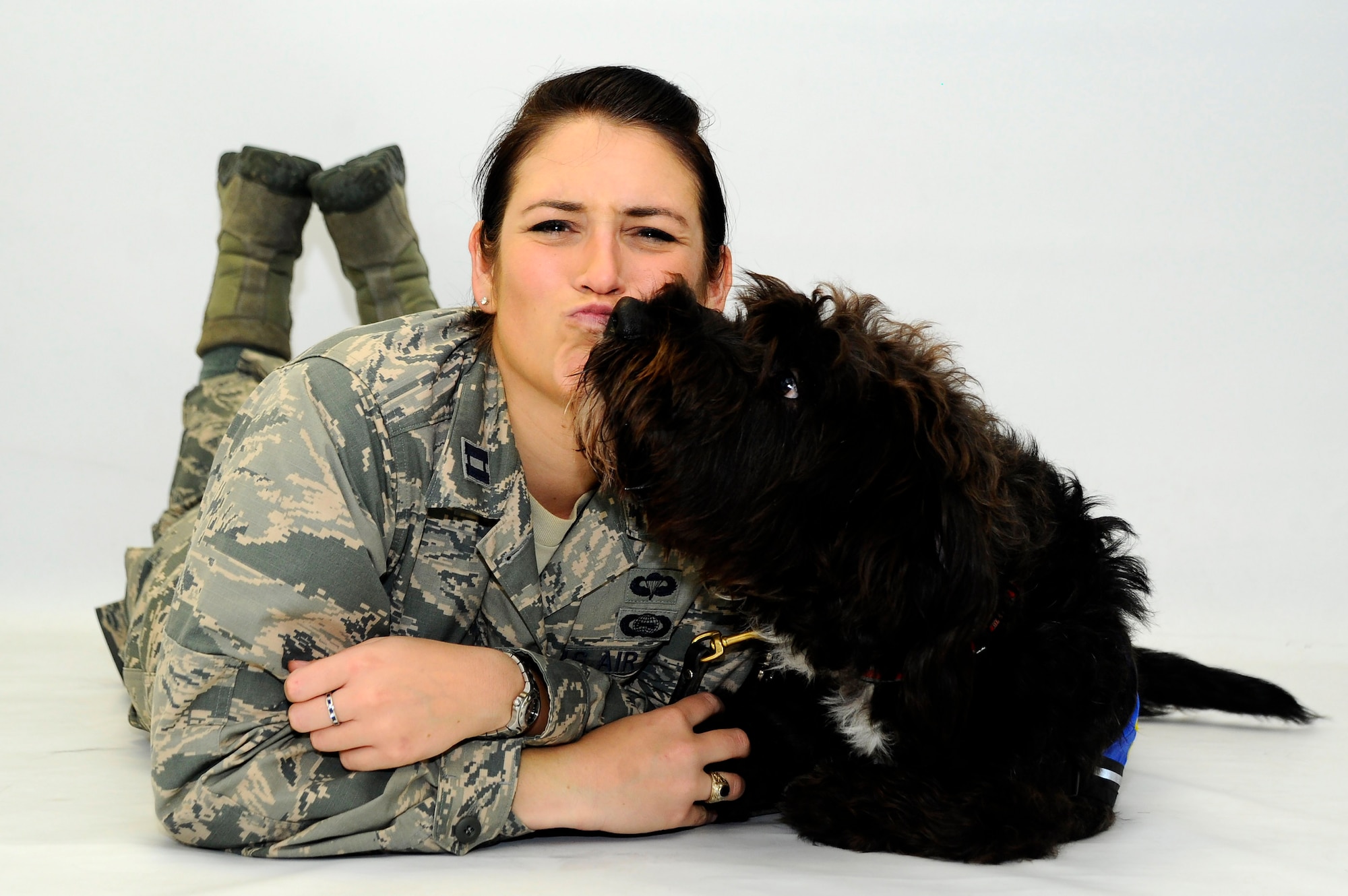 Capt. Carmella Burruss, the 22nd Operations Support Squadron deputy chief of wing intelligence, poses for a photo with Valco on May 25, 2016, at McConnell Air Force Base, Kan. Valco is a Labrador-poodle mix who has been training with Burruss to get his certification from Therapy Dog International so he can work in Veterans Affairs hospitals. (U.S. Air Force photo/Airman 1st Class Jenna K. Caldwell)