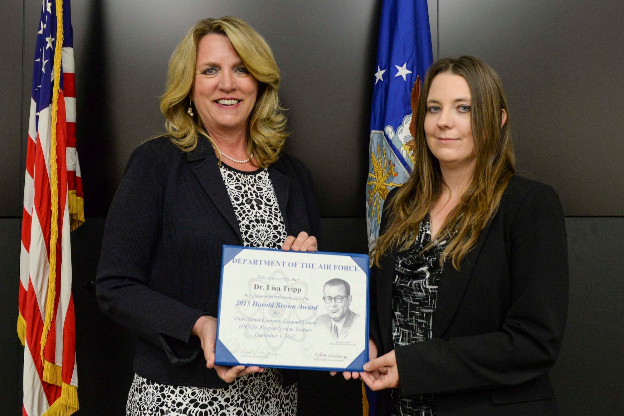 Air Force Secretary Deborah Lee James, left, presents the 2015 Harold Brown Award to Dr. Lisa Tripp during a ceremony June 6, 2016, at Wright-Patterson Air Force Base, Ohio. The award, the highest given by the Air Force to a scientist or engineer, was for Tripp’s efforts in creating innovative and cost-saving training methods and platforms for the Air Force intelligence community. (U.S. Air Force photo/Wesley Farnsworth)