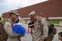 Staff Sgt. Kyle Smail, platoon guide with 5th platoon, Charlie Company, Fleet Anti-Terrorism Team, Marine Corps Security Force Regiment, holds his son as he looks at Cpl. Joshua Mezierre and his daughter (left) after returning to Camp Allen , Norfolk from a seven-month deployment to Bahrain, June 6, 2016. During their deployment, the Marines conducted security operations in the United States Fifth Fleet area of operations, while training alongside other forces in Bahrain, Kuwait, Qatar and Jordan. Along with providing support for their mission, the Marines engaged in training evolutions such as fire team competitions, professional military education and weapon system ranges. (Official Marine Corps photo by Cpl. Calvin Shamoon/ Released)