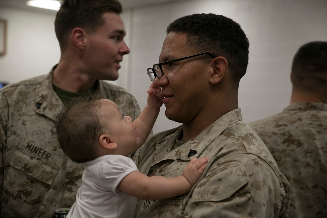 Corporal Joshua Meziere, a grenadier with 5th platoon, Charlie Company, Fleet Anti-Terrorism Team, Marine Corps Security Force Regiment, holds his child as they take his glasses off his face after returning to Camp Allen, Norfolk from a seven-month deployment to Bahrain, June 6, 2016. During their deployment, the Marines conducted security operations in the United States Fifth Fleet area of operations, while training alongside other forces in Bahrain, Kuwait, Qatar and Jordan. Along with providing support for their mission, the Marines engaged in training evolutions such as fire team competitions, professional military education and weapon system ranges. (Official Marine Corps photo by Cpl. Calvin Shamoon/ Released)