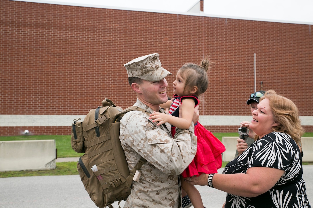 Corporal Jesse Mineer, with 5th platoon, Charlie Company, Fleet Anti-Terrorism Team, Marine Corps Security Force Regiment, hugs his daughter after returning to Camp Allen, Norfolk from a seven-month deployment to Bahrain, June 6, 2016. During their deployment, the Marines conducted security operations in the United States Fifth Fleet area of operations, while training alongside other forces in Bahrain, Kuwait, Qatar and Jordan. Along with providing support for their mission, the Marines engaged in training evolutions such as fire team competitions, professional military education and weapon system ranges. (Official Marine Corps photo by Cpl. Calvin Shamoon/ Released)