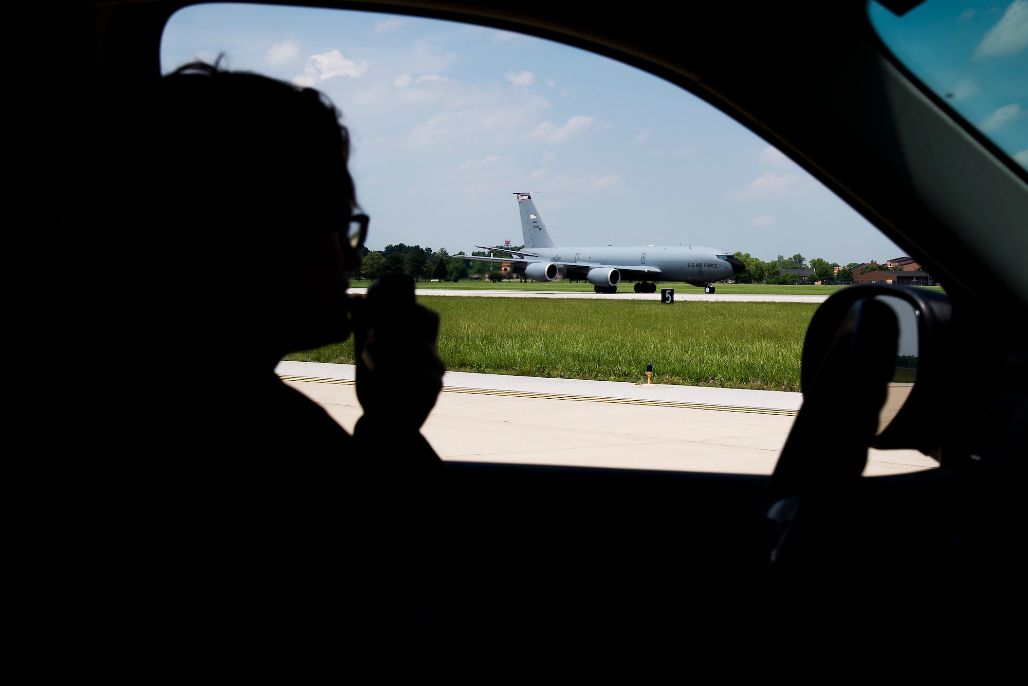 Senior Airman Laura Hackman, 375th Operational Support Squadron airfield managament shift leader, radios for request to another side of the runway while a KC-135 Stratotanker lands at Scott Air Force Base, Illinois on May 24, 2016. When driving on an airfield, vehicles that need access onto the Controlled Movement Area are required to gain permission from Air Traffic Control Tower. This allows ATCT to communicate with vehicle operators to advise where they can and cannot travel to assist with aircraft traffic around and through the aerodrome. (U.S. Air Force Photo by Airman Daniel Garcia)