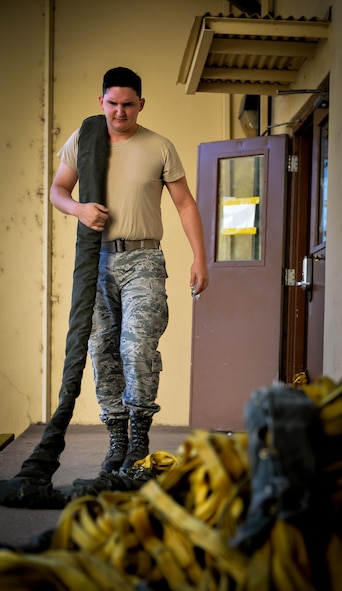 Airman 1st Class Jack McDonald, 2nd Operations Support Squadron aircrew flight equipment journeyman, recovers a deployed drag chute for re-packaging at Barksdale Air Force Base, La., June 7, 2016. Deployed drag shuts were returned to the parachute shop for repackaging. Aircrew flight equipment Airmen repack, inspect and maintain over six chutes a day. (U.S. Air Force photo/Senior Airman Mozer O. Da Cunha)