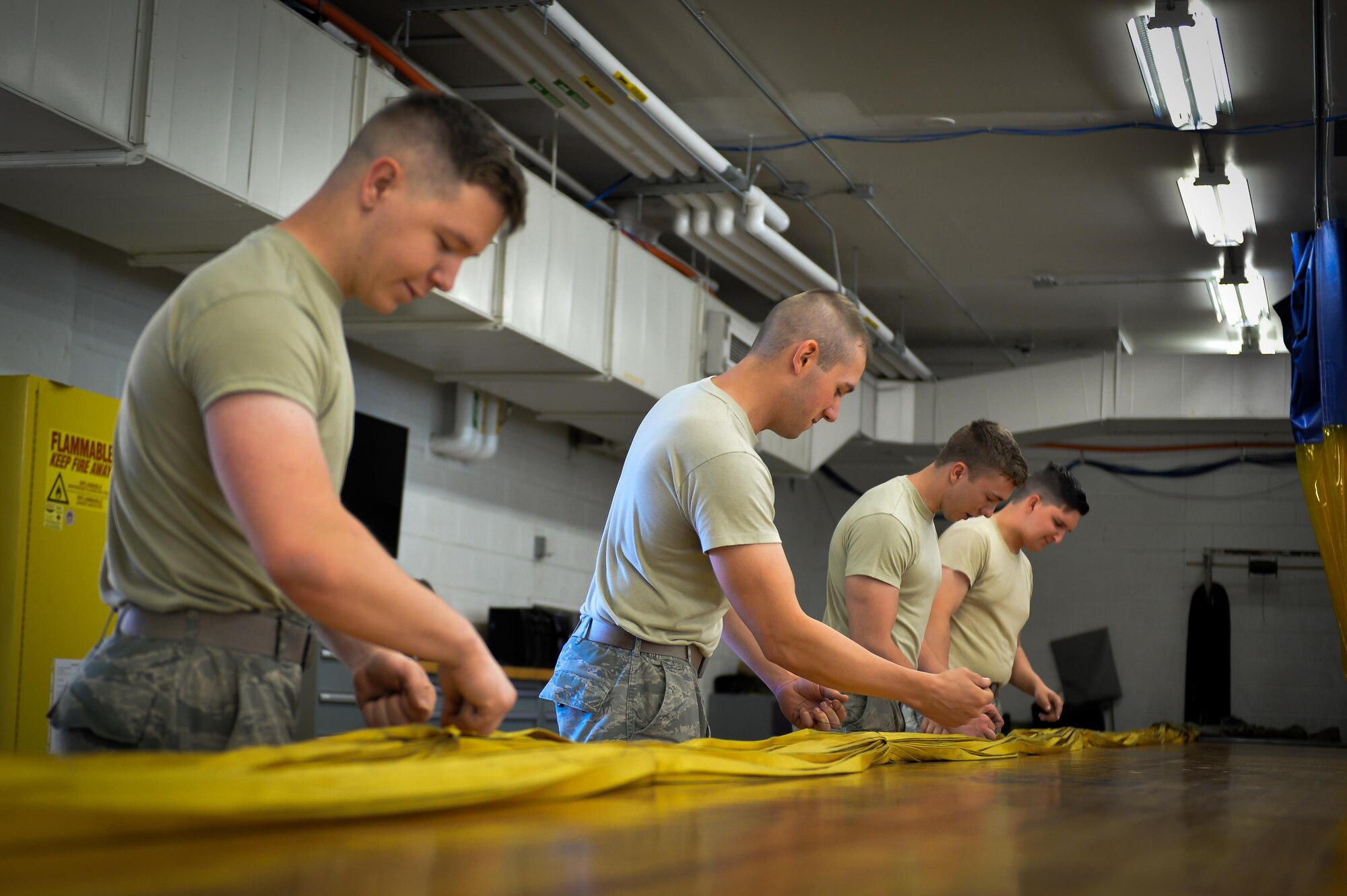 Airman with the 2nd Operations Support Squadron aircrew flight equipment parachute shop sort canopy lines at Barksdale Air Force Base, La., June 7, 2016. Lines were sorted to ensure correct canopy deployment during aircraft landing. The drag is held together by 48 lines that disperse tension between shoot and aircraft. (U.S. Air Force photo/Senior Airman Mozer O. Da Cunha)