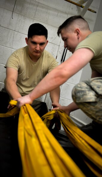 Airmen 1st Class Jack McDonald and Andrew Croft, 2nd Operations Support Squadron aircrew flight equipment journeymen, re-pack a canopy into a chute deployment bag at Barksdale Air Force Base, La., June 7, 2016. The canopy was re-packed by following specific guidelines using techniques such as S-folds and accordion folds to ensure effective deployment during landing. (U.S. Air Force photo/Senior Airman Mozer O. Da Cunha)