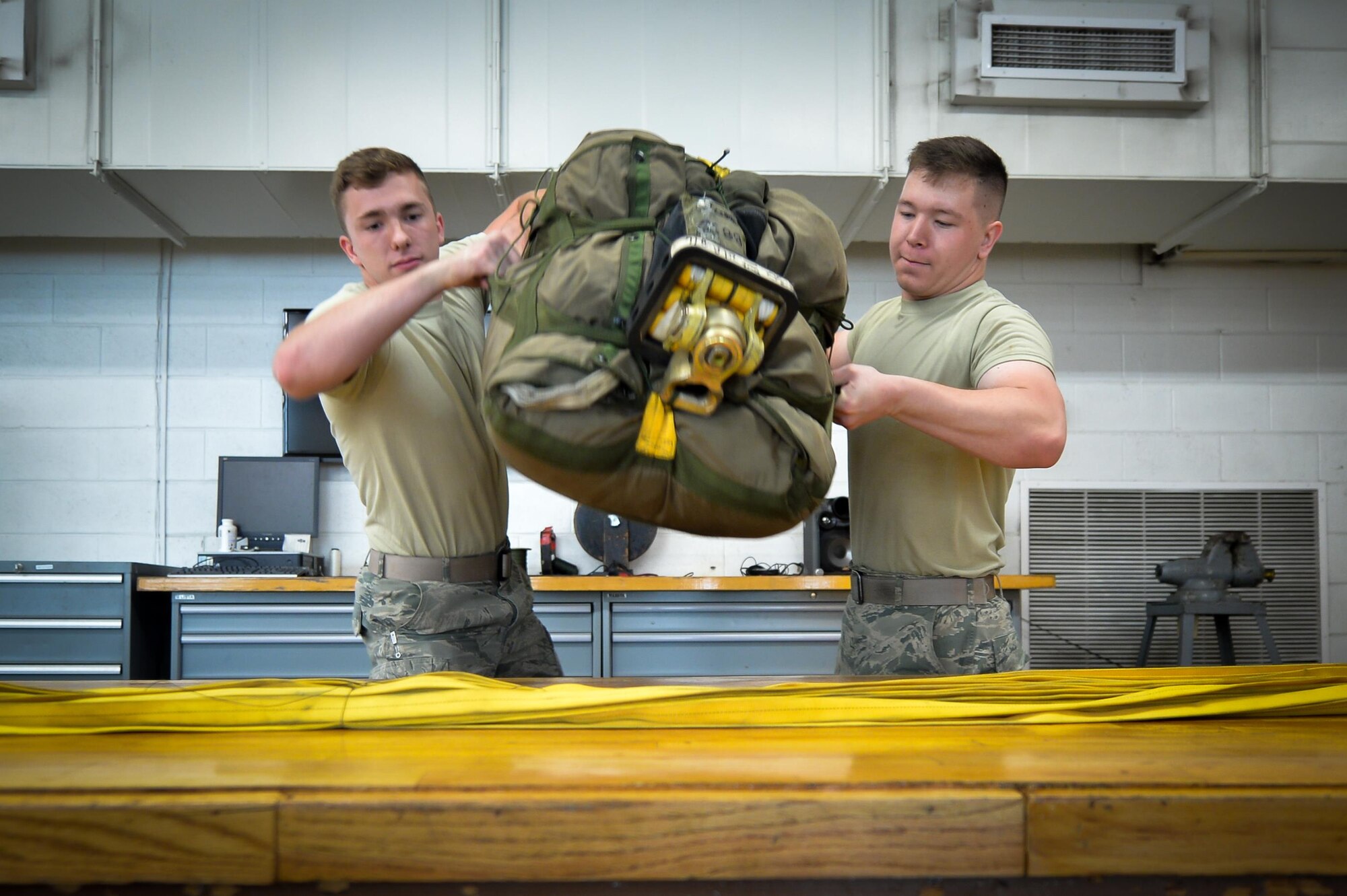 Airmen 1st Class Eric Hornbeck and Andrew Croft, 2nd Operations Support Squadron aircrew flight equipment journeymen, move a re-packed chute deployment bag to a table at Barksdale Air Force Base, La., June 7, 2016. The drag parachute is used to decelerate the B-52 Stratofortress during landing, reducing wear and tear to ceramic pads used by the aircraft, increasing its life span. (U.S. Air Force photo/Senior Airman Mozer O. Da Cunha)
