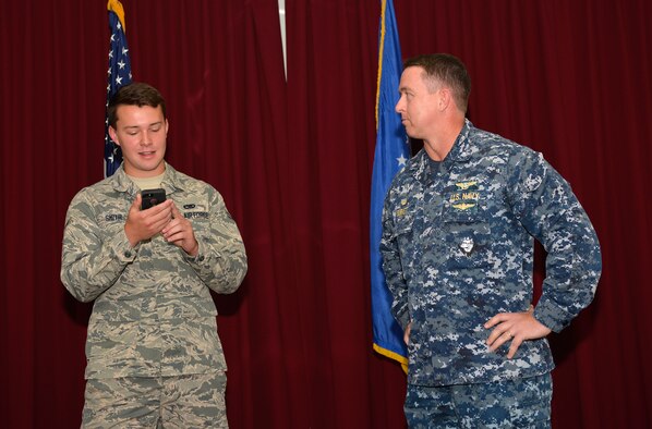 Airman 1st Class Griffin Smith, 33rd Maintenance Squadron aircraft fuels system repairman apprentice, stands with USN Cmdr. Rex Burkett, 33rd Maintenance Squadron commander, and reads an email that identifies A1C Smith as a future U.S. Air Force Academy cadet during a promotion ceremony at Eglin Air Force Base, Fla., June 1, 2016. Smith was selected through the Leaders Encouraging Airman Development program which allows unit commanders to select Airmen they identify have officer potential for the commissioning program. (U.S. Air Force photo/Senior Airman Andrea Posey)