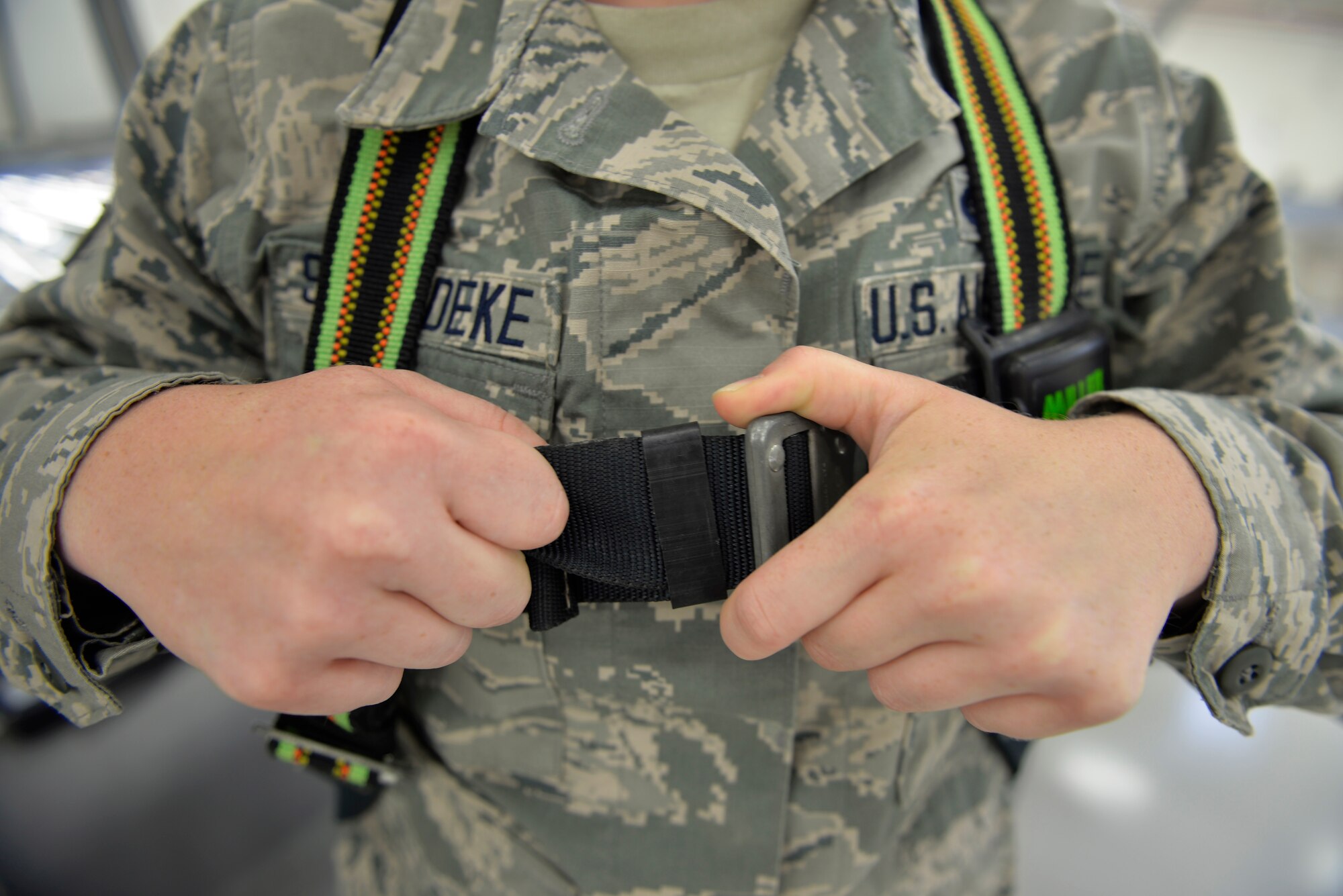 Senior Airman Samantha Schmedeke, 33rd Maintenance Squadron fuel systems journeyman, tightens her harness before conducting maintenance on an F-35A Lightning II at Eglin Air Force Base, Fla., May 16, 2016. Harnesses are a safety precaution to keep Airmen from falling when they maintain parts of the aircraft that must be accessed from on top of the jet. (U.S. Air Force photo/Senior Airman Andrea Posey)