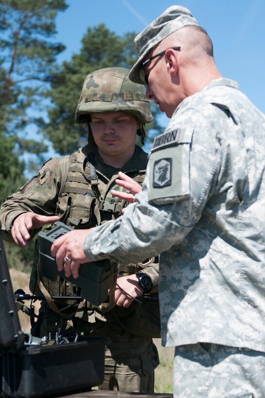 2nd Lt. Damian Michaj, of the 5th Chemical Regiment in the Polish Army, out of Tarnowskie Gory, demonstrates his unit's equipment to Lt. Col. John W. Strain, Commander of the 44th Chemical Battalion from the Illinois National Guard, during Exercise Anakonda 2016, a Polish-led, multinational exercise running from June 7-17. (U.S. Army photo by Spc. Miguel Alvarez/ Released)