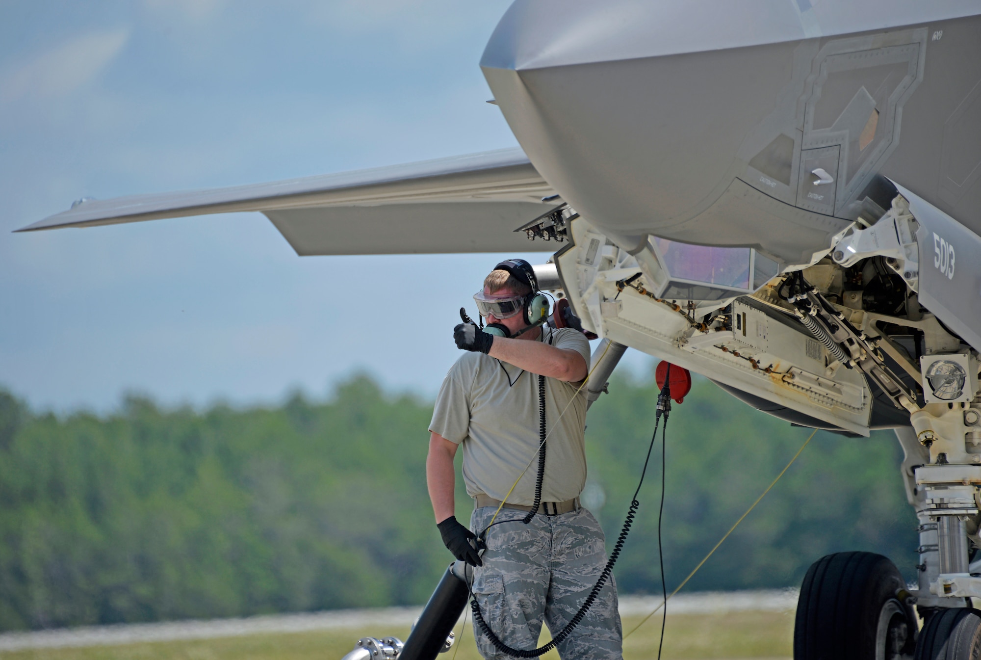Senior Airman Max Todd, 33rd Aircraft Maintenance Squadron crew chief, signals a successful hook-up during the hot pit refueling of an F-35A Lightning II at Eglin Air Force Base, Fla., May 13, 2016. The engines are left running during this type of refueling so pilots are able to return to the air quickly. It can take as little as 20 minutes for a crew chief to fill the nearly 17,000 pound fuel tank. (U.S. Air Force photo/Senior Airman Andrea Posey)