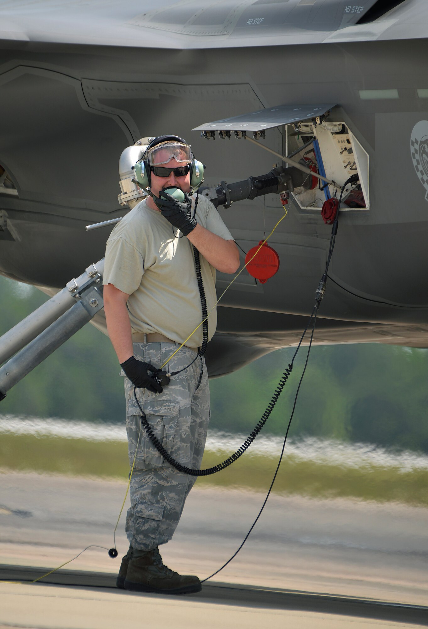 Senior Airman Max Todd, 33rd Aircraft Maintenance Squadron crew chief, speaks to an F-35A Lightning II pilot over the radio during a hot pit refueling at Eglin Air Force Base, Fla., May 13, 2016. While refueling, maintenance Airmen communicate with pilots to gauge how much fuel is loaded into the jet. A hot pit refuel allows aircraft to quickly re-launch for a sortie by fueling with the engine running. (U.S. Air Force photo/Senior Airman Andrea Posey) 