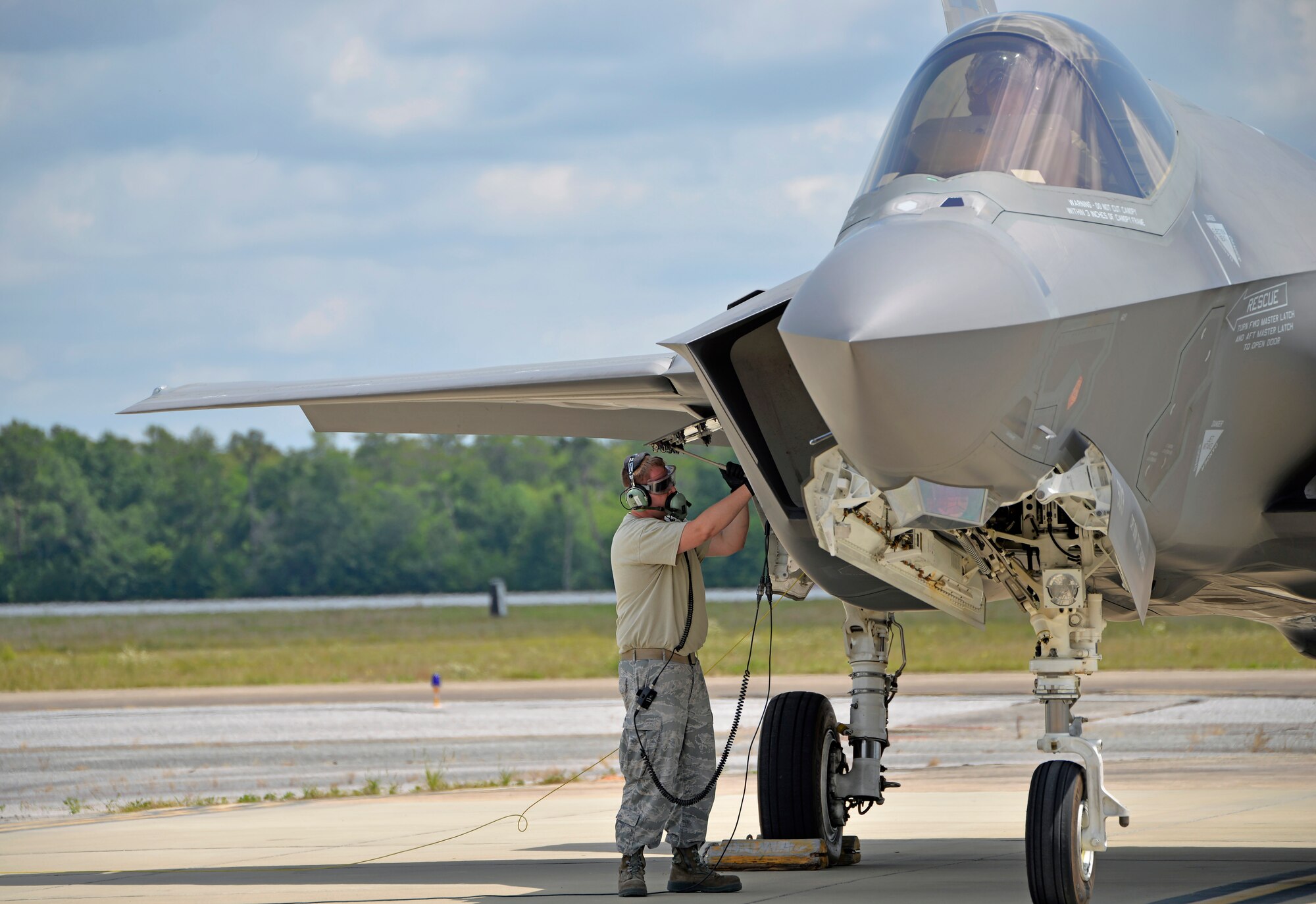 Senior Airman Max Todd, 33rd Aircraft Maintenance Squadron crew chief, closes the maintenance interface panel after a hot pit refueling at Eglin Air Force Base, Fla., May 13, 2016. A hot pit refuel allows aircraft to quickly launch after refueling and is a common practice across the Air Force, especially during wartime. The F-35A Lightning II can hold close to 17,000 pounds of fuel in its tank, this practice gets the aircraft refueled in as few as 20 minutes. (U.S. Air Force photo/Senior Airman Andrea Posey)