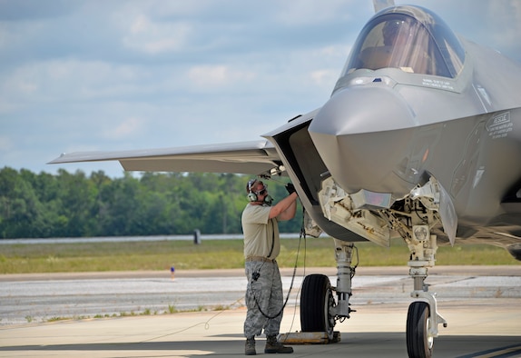 Senior Airman Max Todd, 33rd Aircraft Maintenance Squadron crew chief, closes the maintenance interface panel after a hot pit refueling at Eglin Air Force Base, Fla., May 13, 2016. A hot pit refuel allows aircraft to quickly launch after refueling and is a common practice across the Air Force, especially during wartime. The F-35A Lightning II can hold close to 17,000 pounds of fuel in its tank, this practice gets the aircraft refueled in as few as 20 minutes. (U.S. Air Force photo/Senior Airman Andrea Posey)