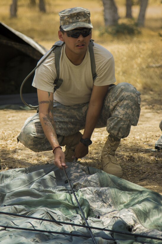 Pfc. Gabriel Ortiz, 341st Military Police Company, sets up his sleeping tent at Fort Hunter Liggett, Calif., June 6, 2016, during the unit's participation in the Combat Support Training Exercise. The purpose of the CSTX is for Army Reserve units to practice their technical skills in a tactical environment under combat-like conditions.  (US Army photo by Cpl. Timothy Yao, 311th Sustainment Command (Expeditionary)/Released)
