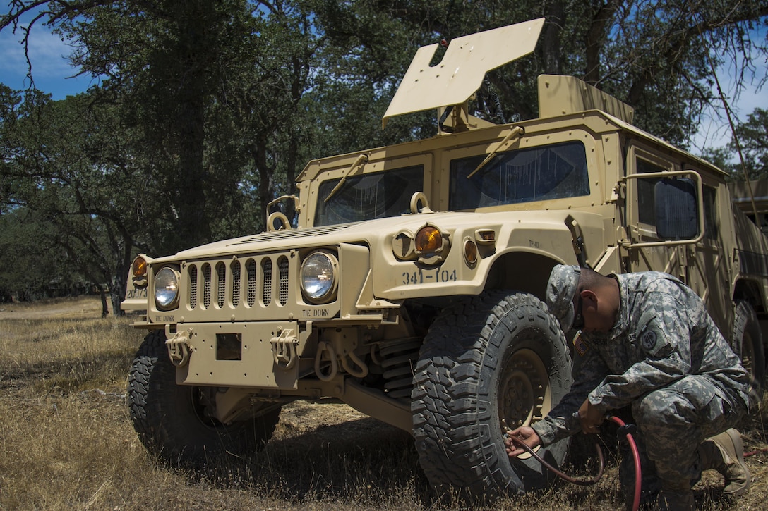 Pvt. Daniel Harrison, 341st Military Police Company, checks and refills air in vehicle tires during the Combat Support Training Exercise, Fort Hunter Liggett, Calif., June 6, 2016. The purpose of the CSTX is for Army Reserve units to practice their technical skills in a tactical environment under combat-like conditions.  (US Army photo by Cpl. Timothy Yao, 311th Sustainment Command (Expeditionary)/Released)