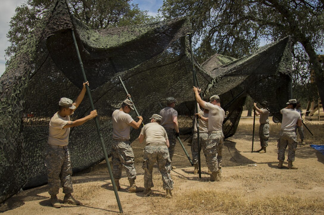 Soldiers from the 451st Sustainment Command (Expeditionary) set up camouflage tent netting for the Combat Support Training Exercise, Fort Hunter Liggett, Calif., June 6, 2016. The CSTX is for Army Reserve units to practice their technical skills in a tactical environment under combat-like conditions.  (US Army photo by Cpl. Timothy Yao, 311th Sustainment Command (Expeditionary)/Released)