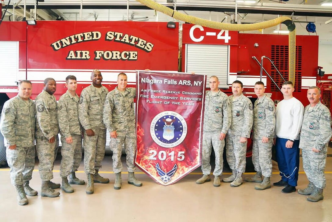 Members of the 914th Airlift Wing Fire Flight pose with the banner for the Air Force Reserve Command Fire Emergency Services of the Year on June 5, 2016 at Niagara Falls Air Reserve Station. The flight beat 26 other units to attain the honor. (U.S. Air Force photo by Staff Sgt. Richard Mekkri/released)