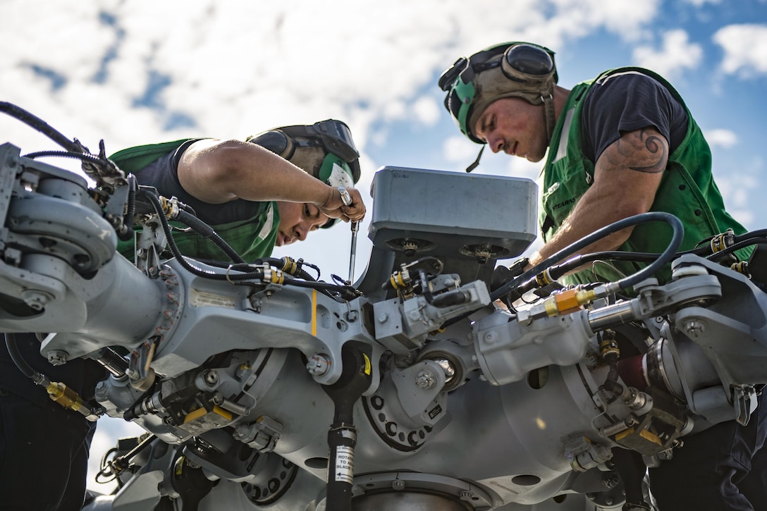 Navy Petty Officer 3rd Class Andrea Ramos, left, and Petty Officer 2nd Class Micah Rupp conduct maintenance on an MH-60S helicopter on the flight deck of hospital ship USNS Mercy in the Pacific Ocean, June 7, 2016, to prepare for the first mission stop in Timor Leste. Ramos and Rupp are aviation structural mechanics assigned to Helicopter Sea Combat Squadrom. Navy photo by Petty Officer 2nd Class Hank Gettys