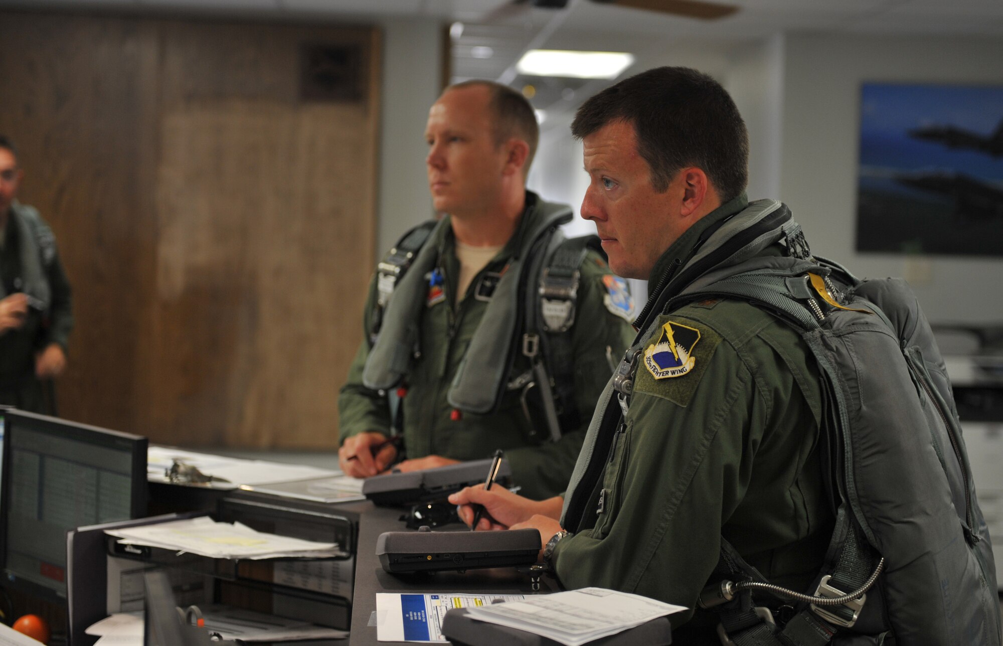 Maj. Justin Hedrick, 2nd Fighter Training Squadron pilot, receives a brief before stepping to his aircraft for a mission June 1, 2016, at the 2nd FTS building. The 2nd FTS is tasked with going head-to-head with the F-22 Raptor, providing world class, professional air-to-air threat replication.