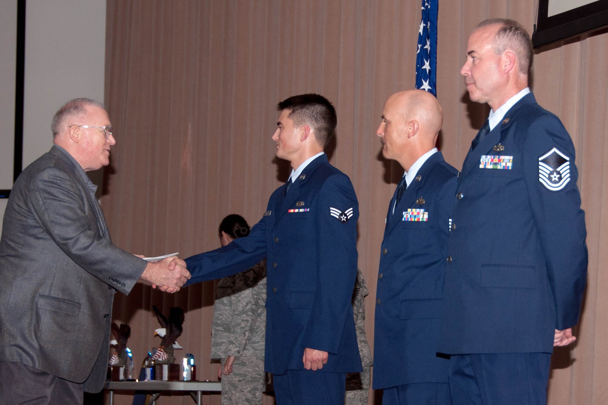 U.S. Air Force Retired Col. David Lay, representing the Military Affairs Council, shakes hands with Senior Airman Nolan Willmon, 307th Maintenance Squadron, during a Commander’s Call at Barksdale Air Force Base, La., June 5, 2016. Willmon was named the 307th Bomb Wing Airman of the Quarter for the first quarter. (U.S. Air Force photo by Master Sgt. Laura Siebert/Released)