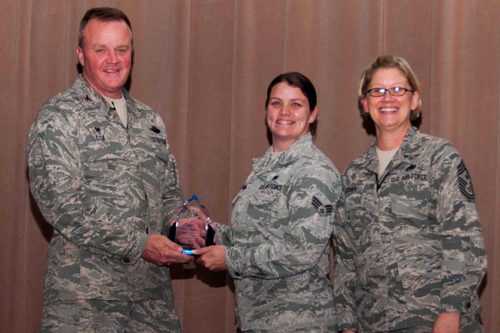 U.S. Air Force Senior Airman Rachel Upshaw is presented a plaque by the 307th Bomb Wing Commander, Col. Bruce Cox, and for the 307th Bomb Wing Command Chief, Chief Master Sgt. Shelley Cohen, for 2015 Crew Chief of the Year, Chief Master Sgt. Thomas N. Barnes Award during Commander’s Call on Barksdale Air Force Base, La., June 5, 2016. Upshaw is assigned to the 707th Maintenance Squadron and is being recognized for her exemplary job performance, efficiency and knowledge in her career field. (U.S. Air Force photo by Master Sgt. Laura Siebert/Released)