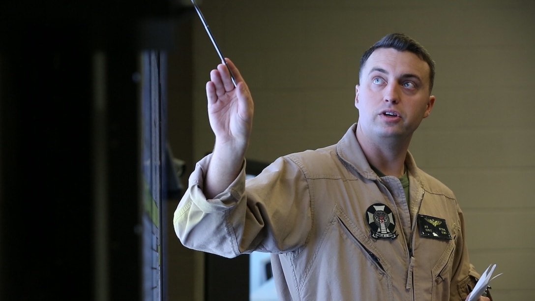 A pilot with Marine Light Attack Helicopter Squadron (HMLA) 169 briefs pilots on key objective locations during Virtual Flag aboard Marine Corps Air Station Camp Pendleton, Calif., May 18. Virtual Flag is the flagship event for the U.S. Air Force Distributed Missions Operations Center of Excellence (DMOC) and is a quarterly exercise among military branches using various aircraft and mechanized simulators across the country. (U.S. Marine Corps photo by Sgt. Brian Marion/Released)