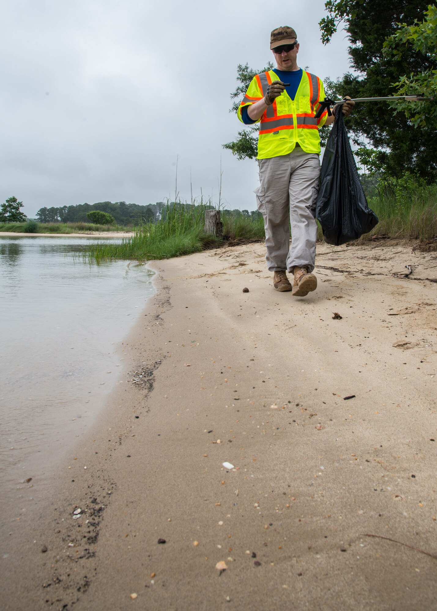 U.S. Army Sgt. 1st Class Mark Avant, Operations non-commissioned officer assigned to the 128th Aviation Brigade, examines a discarded shotgun shell case while cleaning Sword beach at Fort Eustis, Va., June 4, 2016. In 2015 approximately 6,000 volunteers removed roughly 105,000 pounds of harmful debris from over 275 sites along more than 450 miles of streams and shoreline (U.S. Air Force photo by Staff J.D. Strong II)