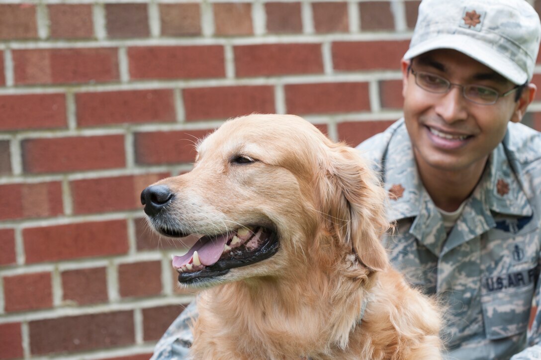 U.S. Air Force Maj. Alvi Azad, a surgeon assigned to the 497th Intelligence, Surveillance and Reconnaissance Group, provides 480th ISR Wing Airmen with the opportunity to spend time with his therapy dog, Lucky, at Langley Air Force Base, Va., May 10, 2016. Lucky, a 5-year-old Golden Retriever, uses his therapy dog training to help boost morale for Airmen who spend countless hours dealing with intense missions. (U.S. Air Force photo by Airman 1st Class Kaylee Dubois)