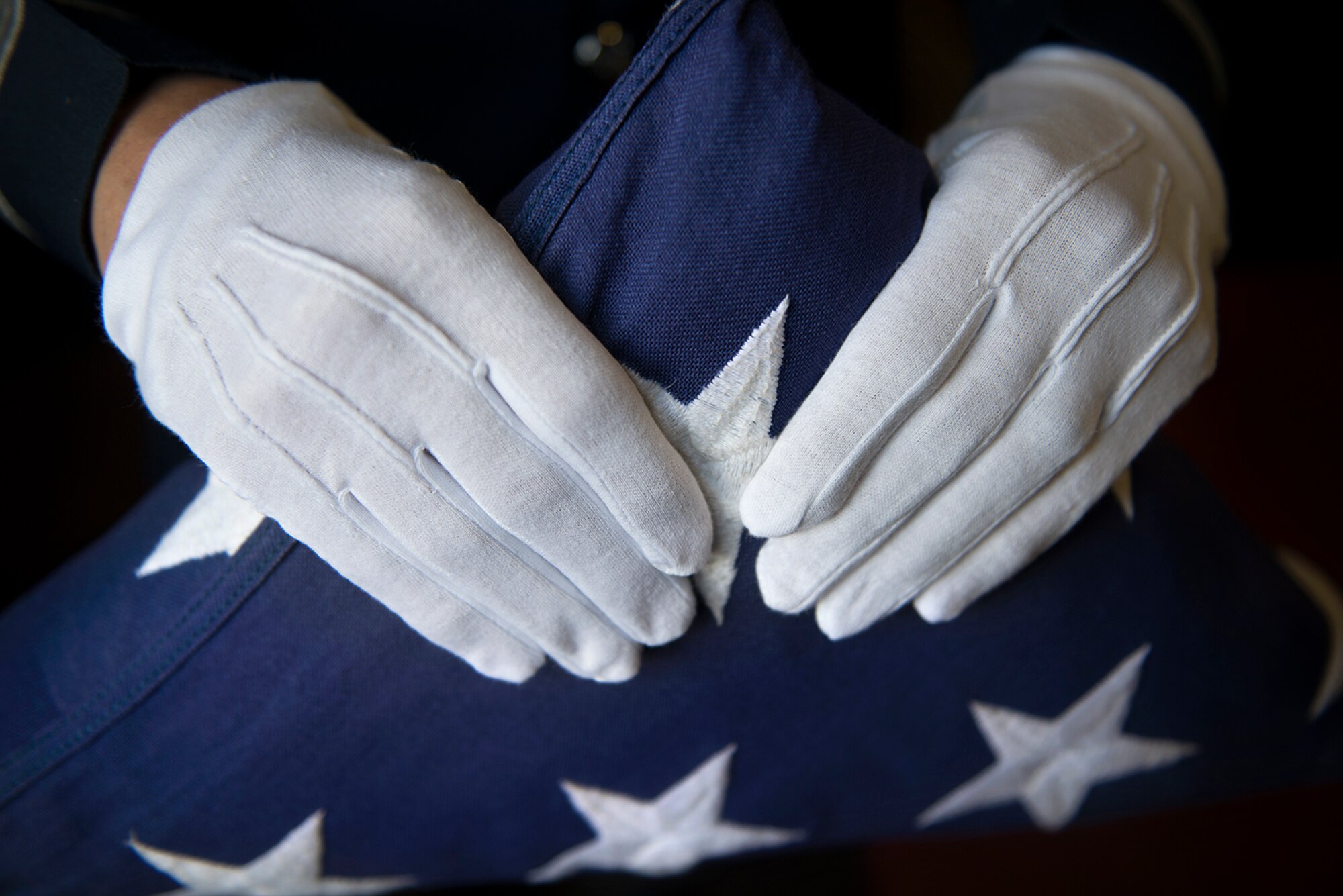 Air Force Staff Sgt. Jordan Hayes, 673rd Force Support Squadron, noncommissioned officer in charge of the Joint Base Elmendorf-Richardson Honor Guard, presents a properly folded flag at Matanuska Hall, June 2, 2016. June 14 is national Flag Day, and individuals should exercise caution to make sure they are properly representing the flag during the celebration. (U.S. Air Force photo by Senior Airman Kyle Johnson/Released)