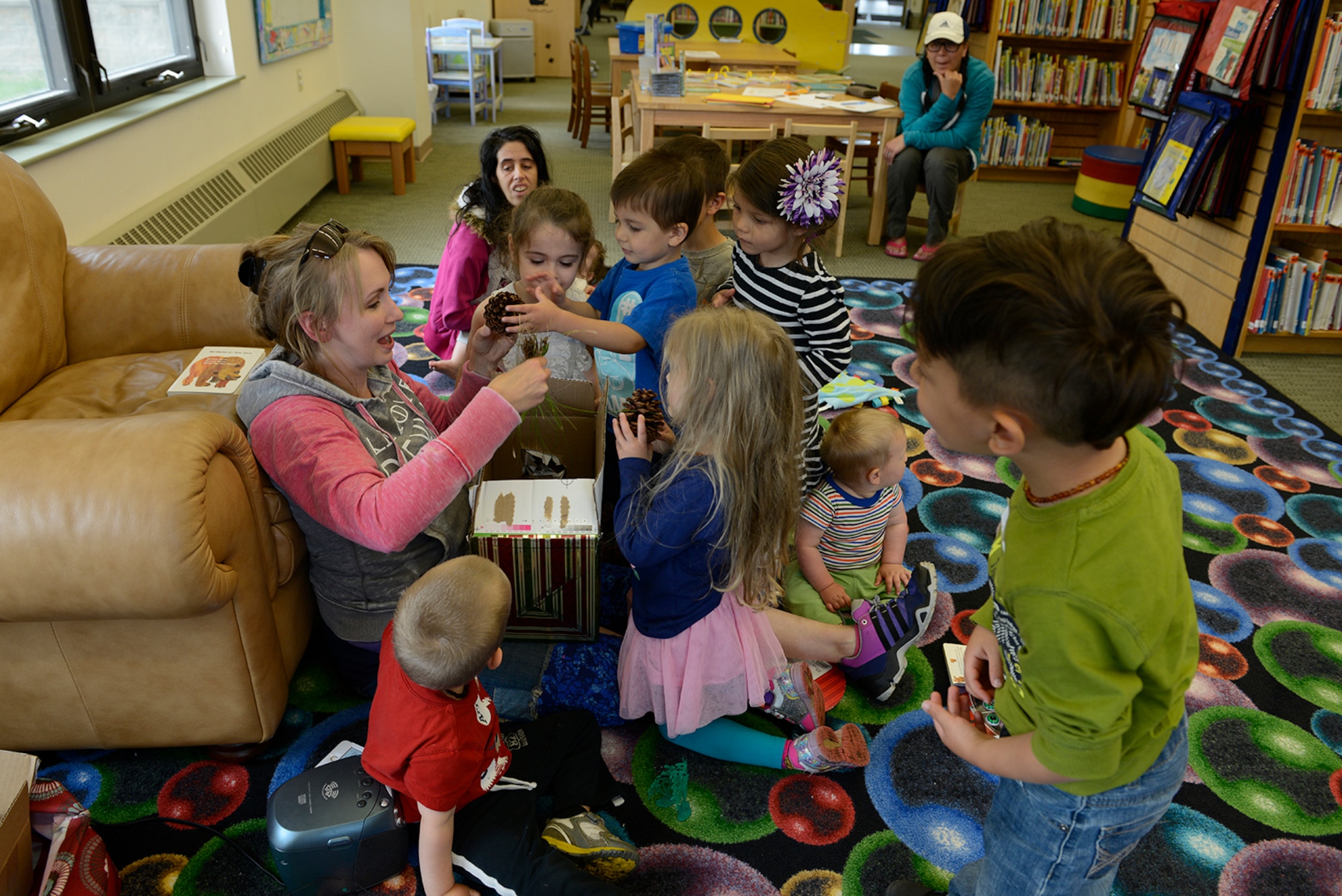 Children open a box full of grass and pinecones during an American Sign Language class designed for preschool children at the Joint Base Elmendorf-Richardson Library, Alaska, June 4, 2016. ASL has many regional and dialectal differences depending on age, gender, culture and more. (U.S. Air Force photo by Airman 1st Class Valerie Monroy)