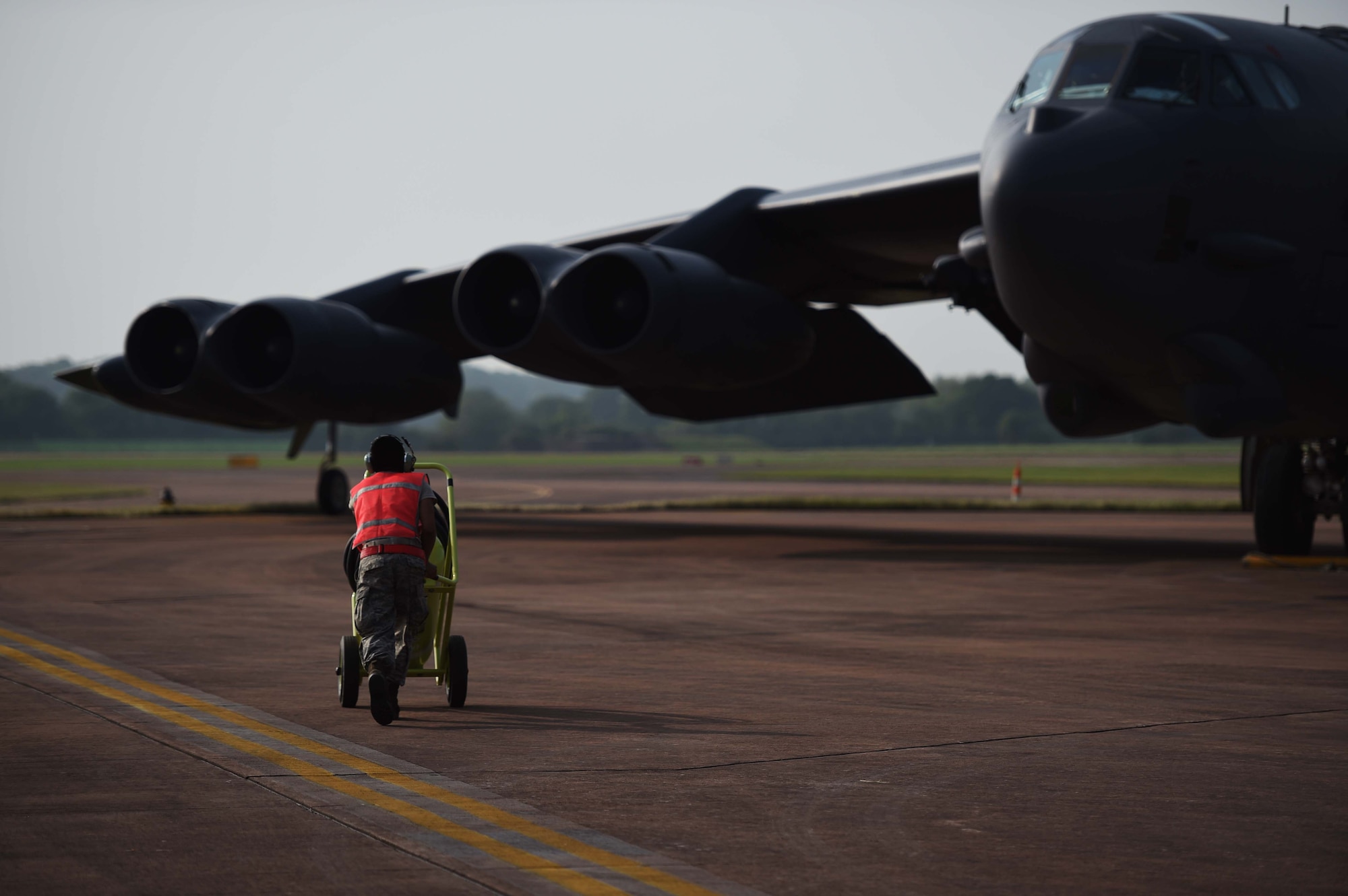 A maintenance Airman from Minot Air Force Base, N.D., runs to a B-52H Stratofortress as it parks on Royal Air Force Fairford, United Kingdom, June 7, 2016, after flying a training sortie in support of exercise BALTOPS 16. The mission trained the aircrew on air interdiction and interoperability with sister services and partner nations. (U.S. Air Force photo/Airman 1st Class Zachary Bumpus)