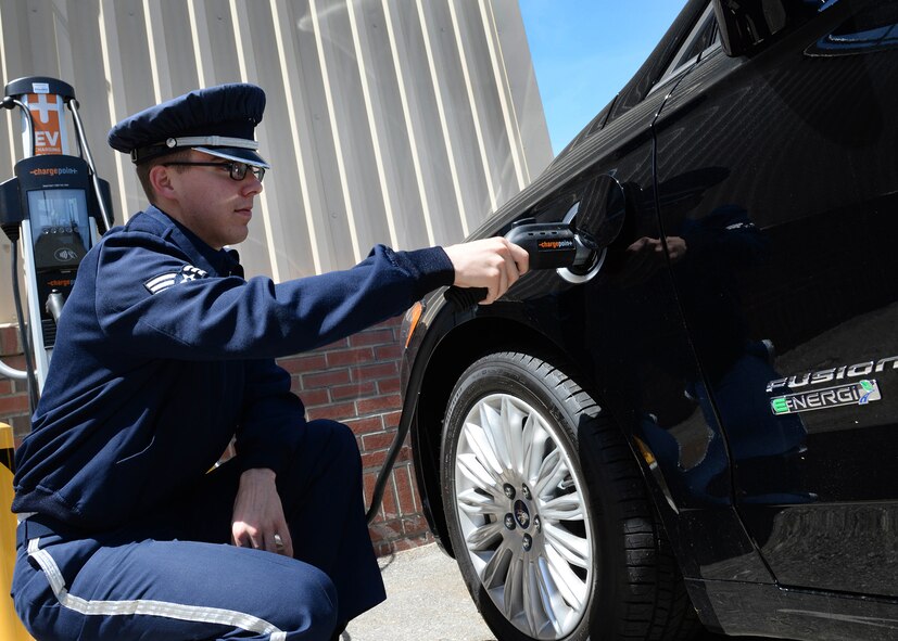 Senior Airman Alec Cope, a ceremonial guardsman with the Patriot Honor Guard, plug-ins an electric Hybrid vehicle outside Building 1646 at Hanscom Air Force Base, Mass., June 2. The 66th Logistics Readiness Squadron recently unveiled the plug-in electric hybrid vehicle and charging station during an open house. The vehicle complies with President Barack Obama's federal government directive to become more energy efficient with the Department of Defense’s vehicle fleet. (U.S. Air Force photo by Linda LaBonte Britt)

