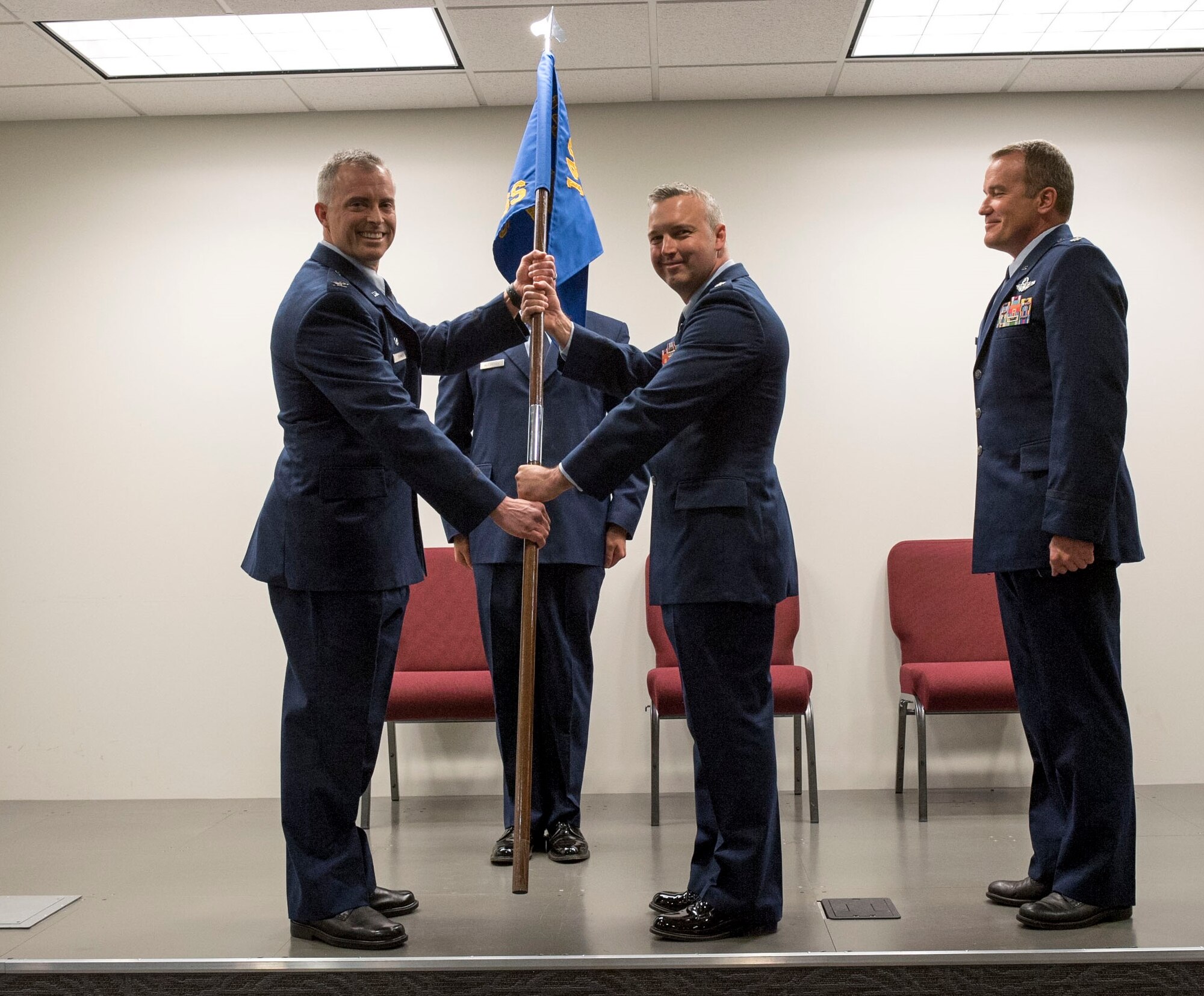 Colorado Air National Guard Col. Brian D. Turner, commander, 140th Operations Group, presents the guidon to Lt. Col. Jeremiah S. Tucker as he assumes command of the 140th Operations Support Squadron (OSS),  June 5, 2016, Buckley Air Force Base, Aurora, Colo. The 140 OSS was previously under the command of Lt. Col. Scott D. Van Beek (right), special projects officer, 140 Wing Plans.  (U.S. Air National Guard photo by Staff Sgt. Michelle Y. Alvarez-Rea)