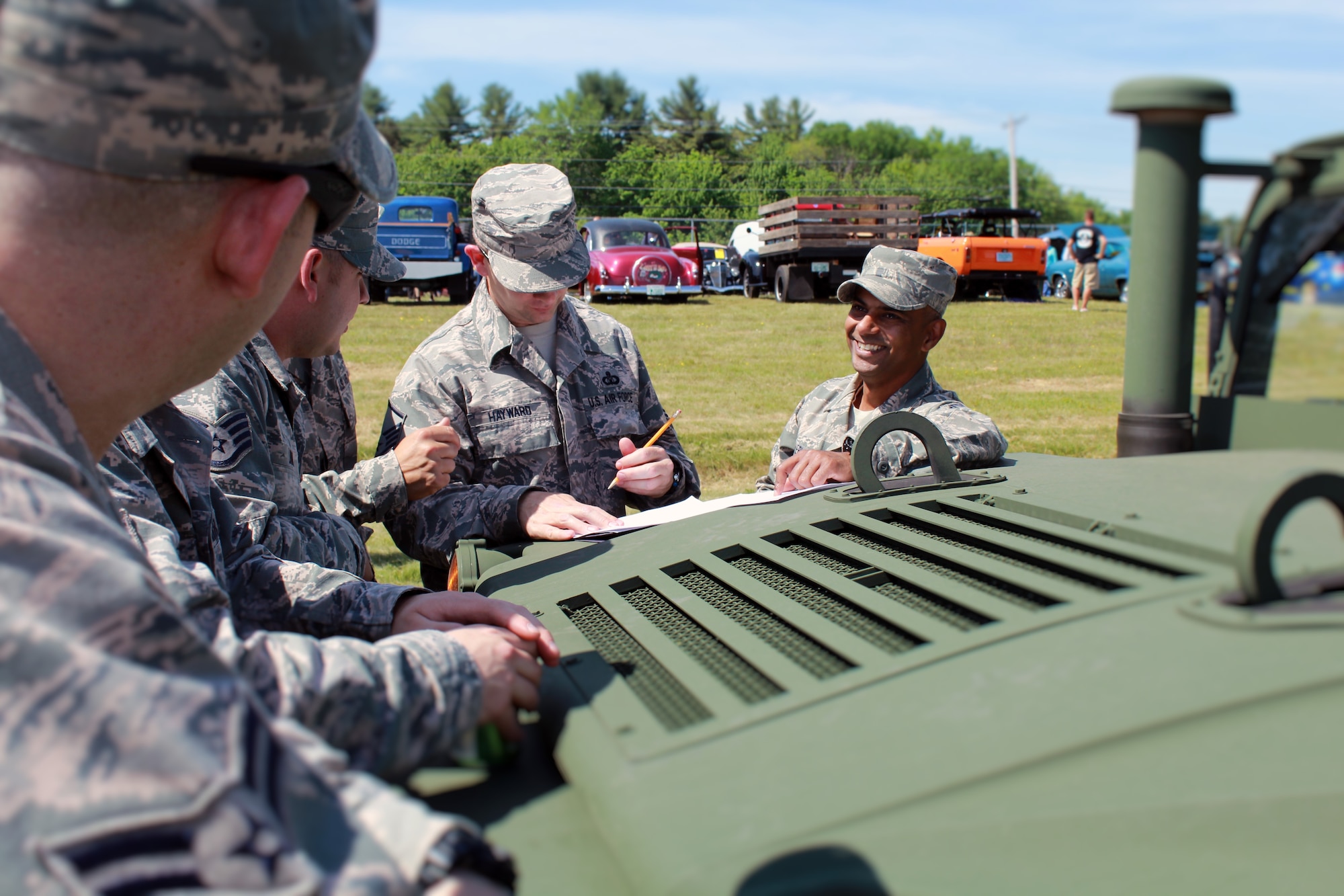 U.S. Air Force Senior Master Sgt. Pranav Zaveri, mobile tower chief controller, and other members of the 260th Air Traffic Control Squadron discuss the MSN-7 Mobile Control Tower display at the Wings and Wheels community event in Rochester, N.H. June 4, 2016. The Airmen greeted and spoke with community members and families attending the event, and showed them how MSN-7 can be used for more than just military purposes. (U.S. Air National Guard photo by Staff Sgt. Kayla Rorick)