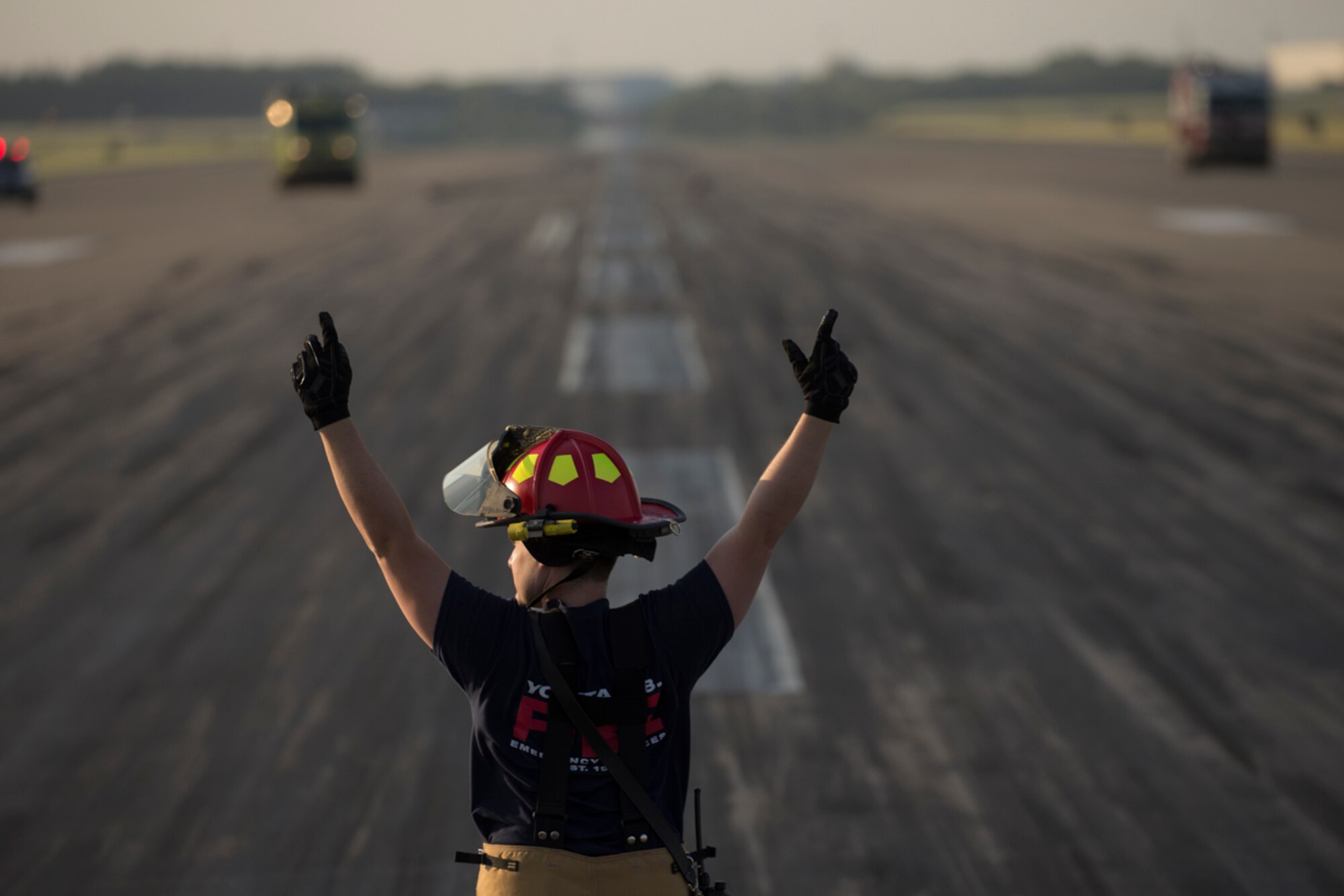 Staff Sgt. Richard Austin, 374th Civil Engineer Squadron fire department crew chief, signals for his team members to reel in the nylon tape from the aircraft arresting system at Yokota Air Base, Japan, June 3, 2016. The 374th Civil Engineer Squadron power productions shop and fire department and 374th Operations Support Squadron airfield management flight are responsible for testing the system annually. (U.S. Air Force photo by Yasuo Osakabe/Released)   