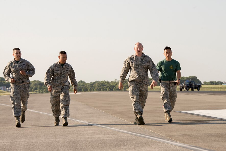 Airmen with the 374th Civil Engineer Squadron check the nylon tape for the aircraft arresting system at Yokota Air Base, Japan, June 3, 2016. The tape is stored on reels connected to AAS absorbers secured on both sides of the runway and has a 1,200-foot runout. (U.S. Air Force photo by Senior Airman David C. Danford/Released)