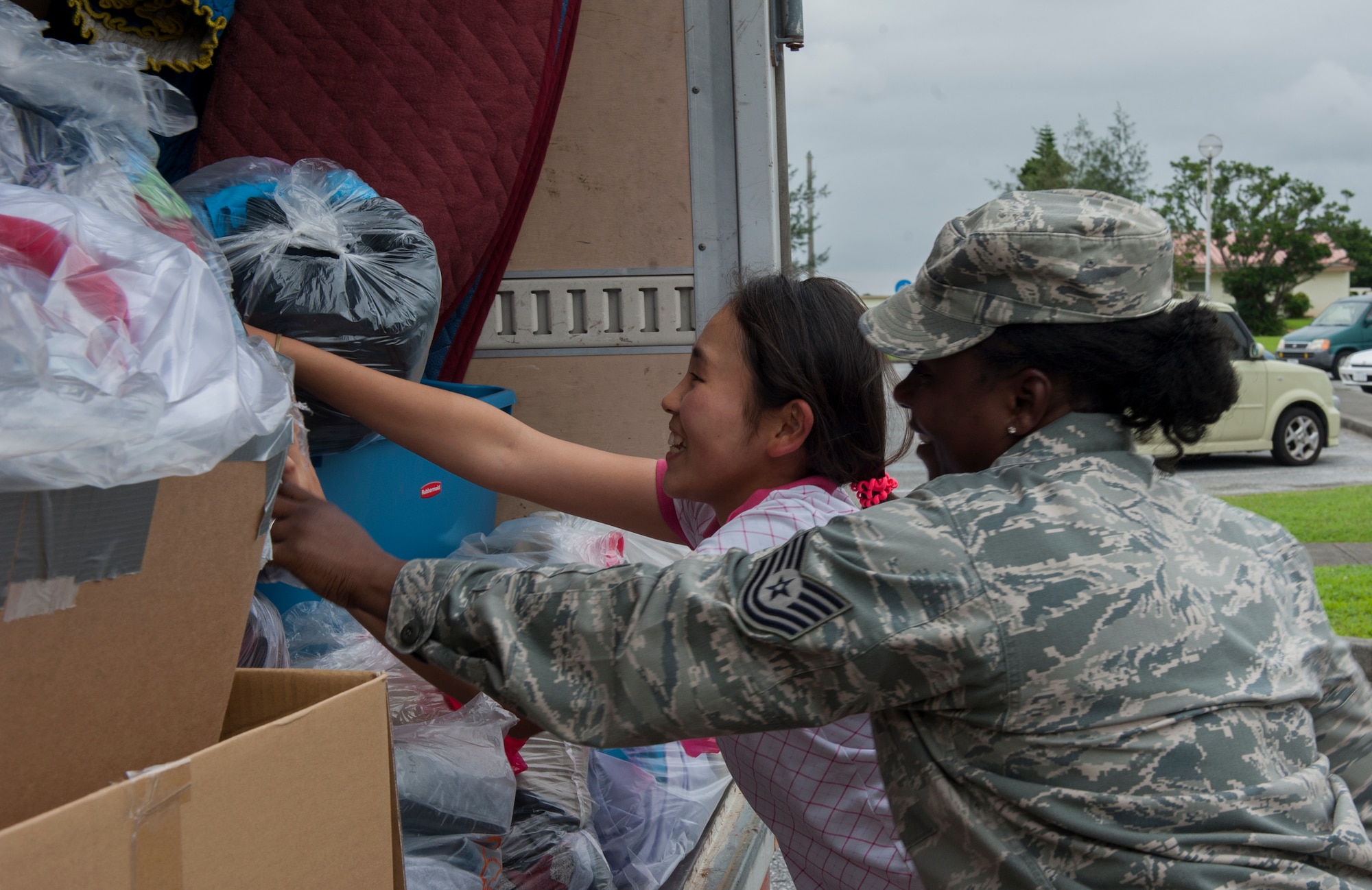 U.S. Air Force Tech. Sgt. Kahlila Mutidi, Air Force Sergeants Association Chapter 1553 outreach committee lead and 18th Civil Engineer Group safety manager, helps Miku Hanashiro pack a truck full of clothes, June 2, 2016, at Kadena Air Base, Japan. Kadena’s Air Force Sergeants Association Chapter 1553 assisted Promise Keepers, a local non-profit organization, with gathering clothes to donate to the local community. (U.S. Air Force photo by Airman 1st Class Lynette M. Rolen)