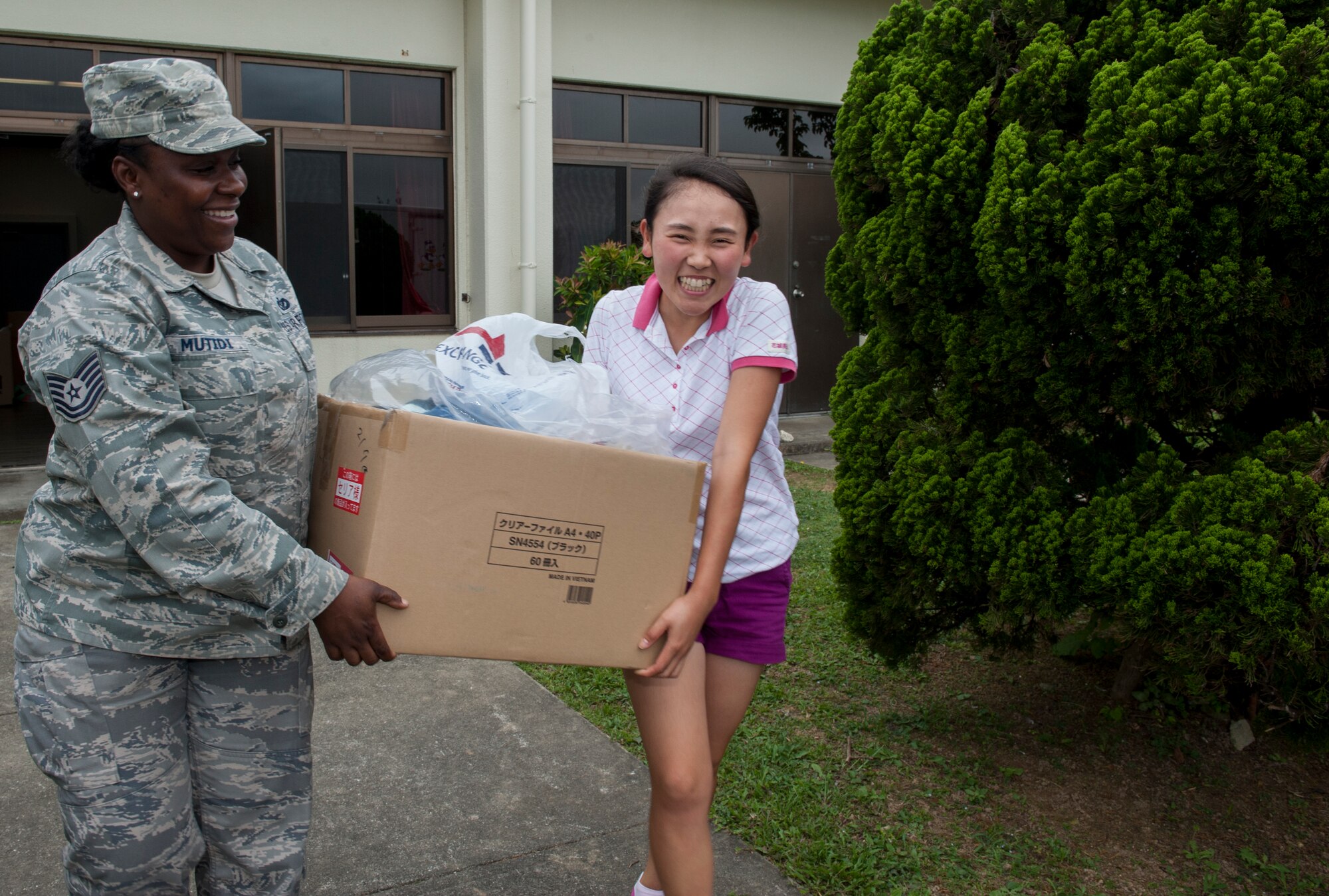 U.S. Air Force Tech. Sgt. Kahlila Mutidi, Air Force Sergeants Association Chapter 1553 outreach committee lead and 18th Civil Engineer Group safety manager, helps Miku Hanashiro, Promise Keepers volunteer, carry a box of clothes, June 2, 2016, at Kadena Air Base, Japan. Kadena’s Air Force Sergeants Association Chapter 1553 assisted Promise Keepers, a local non-profit organization, with gathering clothes to donate to the local community. (U.S. Air Force photo by Airman 1st Class Lynette M. Rolen)