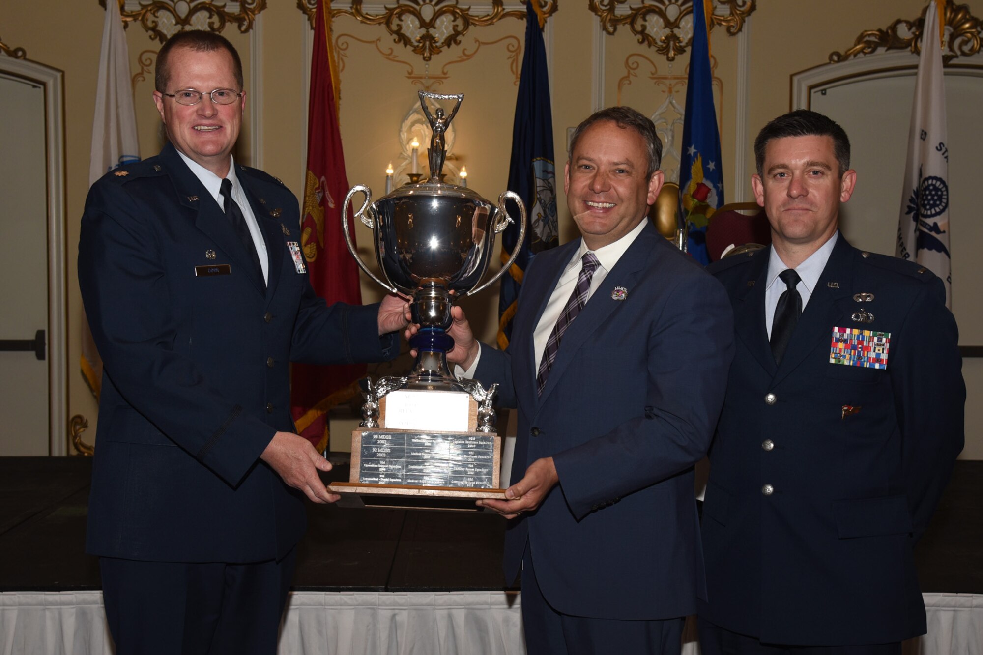 Lt. Col. James Dorn, 92nd Aircraft Maintenance Squadron commander, and 1st Lt. Dan Reed, 92nd AMXS aircraft maintenance unit officer in charge, accept the Neal Fosseen Award from Spokane Mayor, David Condon, during a community event May 19, 2016, in Spokane, Wash. The 92nd AMXS has won this prestigious award two years in a row for thousands of man-hours dedicated to the Spokane community and their overall excellence in community service.