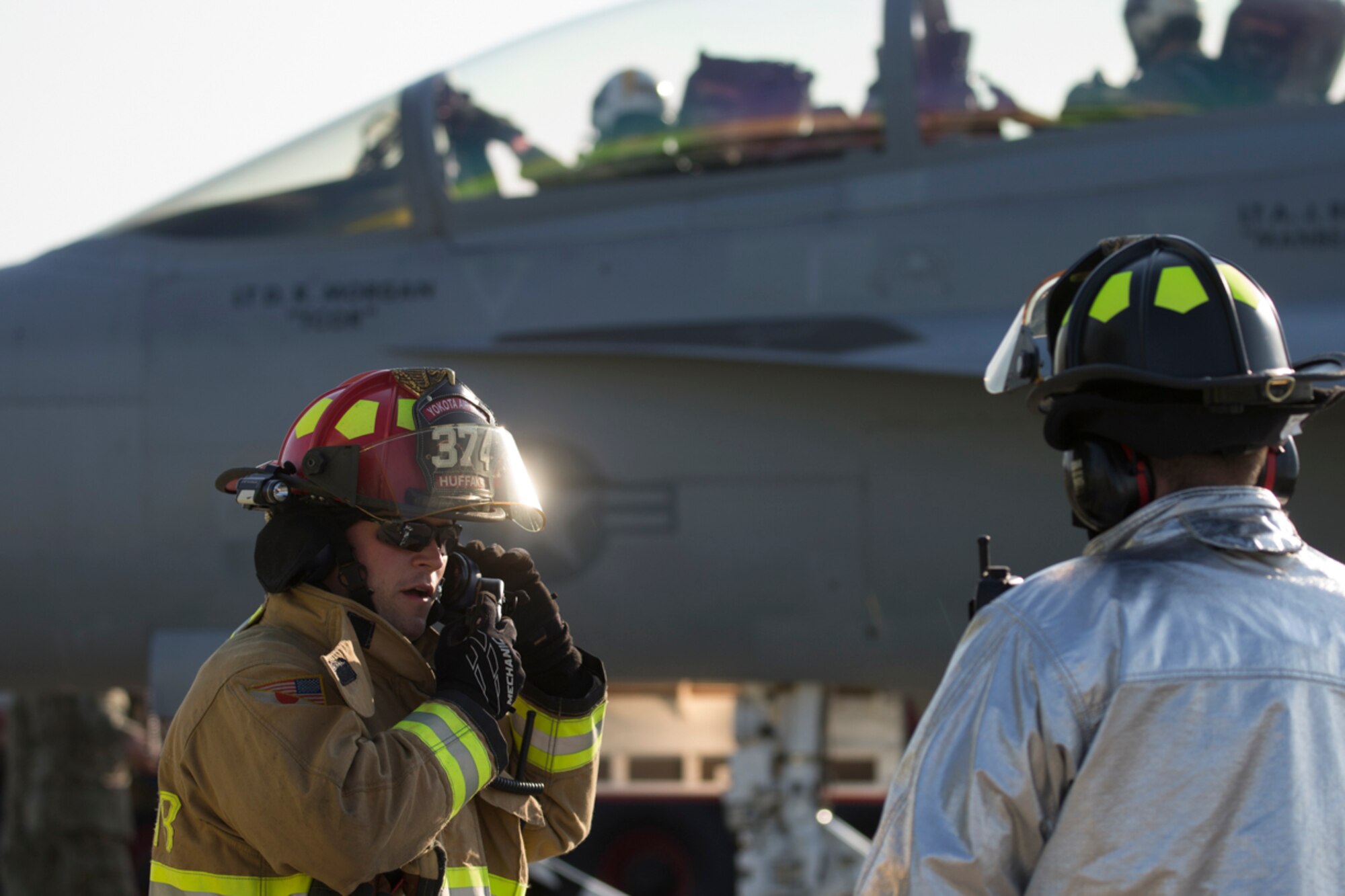 Staff Sgt. Richard Austin, 374th Civil Engineer Squadron fire department crew chief, radios his crew members during an annual certification test of an aircraft arresting system at Yokota Air Base, Japan, June 3, 2016. The 374th Civil Engineer Squadron power productions shop and fire department and 374th Operations Support Squadron airfield management flight are responsible for testing the system annually. (U.S. Air Force photo by Yasuo Osakabe/Released)