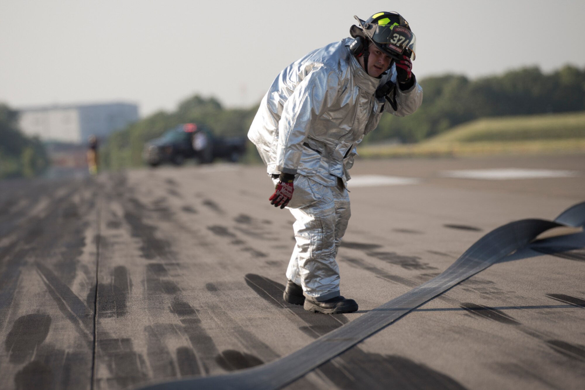 Senior Airman Kirk Ebel, 374th Civil Engineer Squadron firefighter, checks  the nylon tape from the aircraft arresting system during an annual certification test of an AAS at Yokota Air Base, Japan, June 3, 2016. The 374th Civil Engineer Squadron power productions shop and fire department and 374th Operations Support Squadron airfield management flight are responsible for testing the system annually. (U.S. Air Force photo by Yasuo Osakabe/Released)