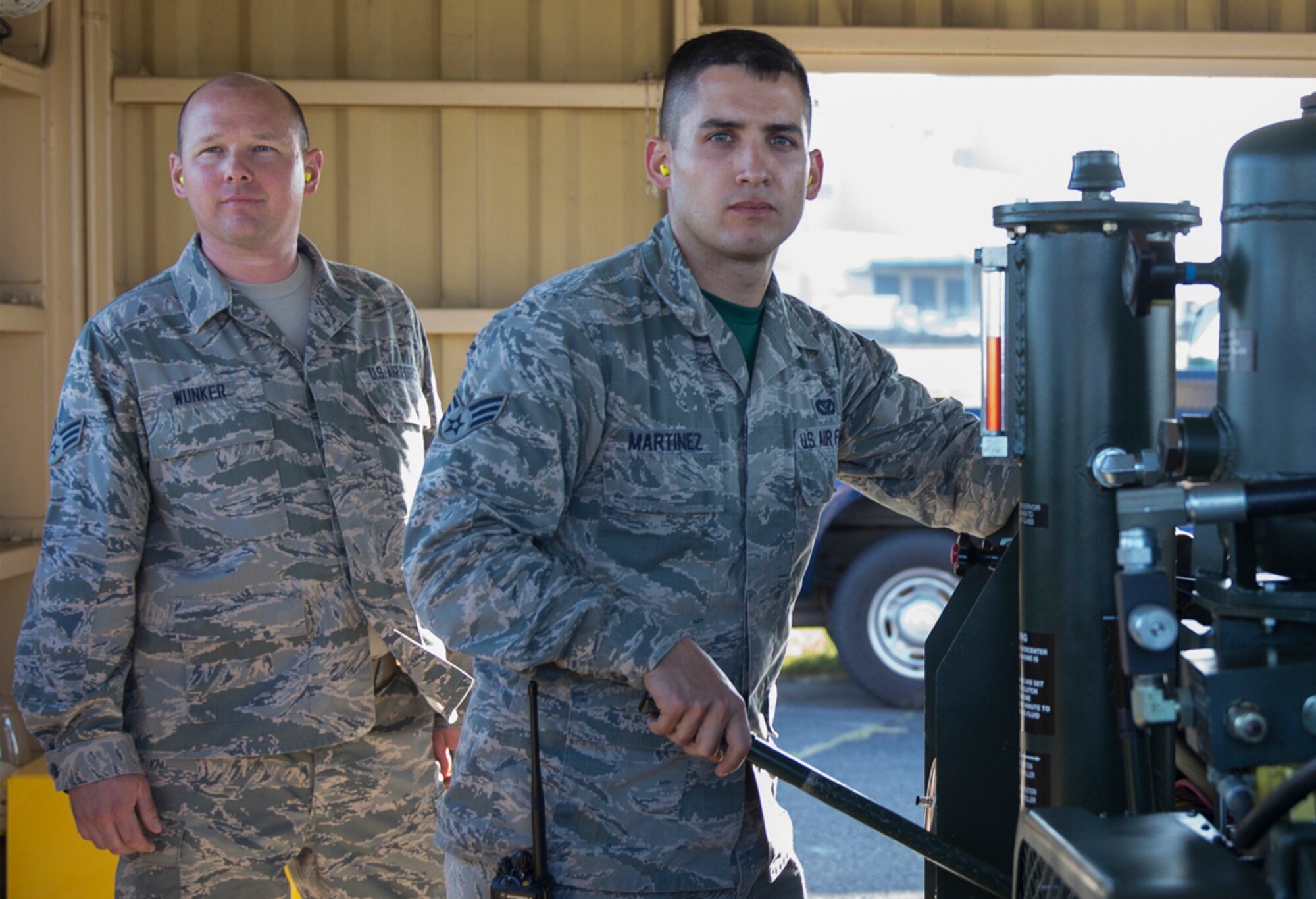 (Right to left) Senior Airman David Martinez, 374th Civil Engineer Squadron electrical power productions technician, and Senior Airman Timothy Wunker, 919th Special Operations Civil Engineer Squadron electrical power productions technician, operate a BAK-12 aircraft arresting system during an annual certification test at Yokota Air Base, Japan, June 3, 2016. The system went through an annual certification test with an EA-18G Growler to ensure its operability following installation by the 374th Civil Engineer Squadron power productions shop. (U.S. Air Force photo by Yasuo Osakabe/Released)