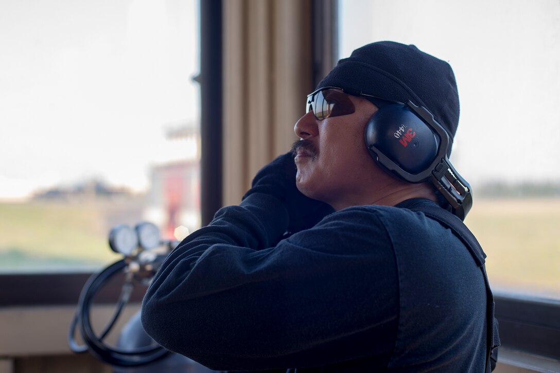 Kei Kurokawa, 374th Civil Engineer Squadron fire department vehicle operator, communicates with Airmen on the flightline to safely reel in the nylon tape from the aircraft arresting system at Yokota Air Base, Japan, June 3, 2016. The 374 CES and 374th Operations Support Squadron airfield management flight are responsible for testing the system annually. (U.S. Air Force photo by Senior Airman David C. Danford/Released)